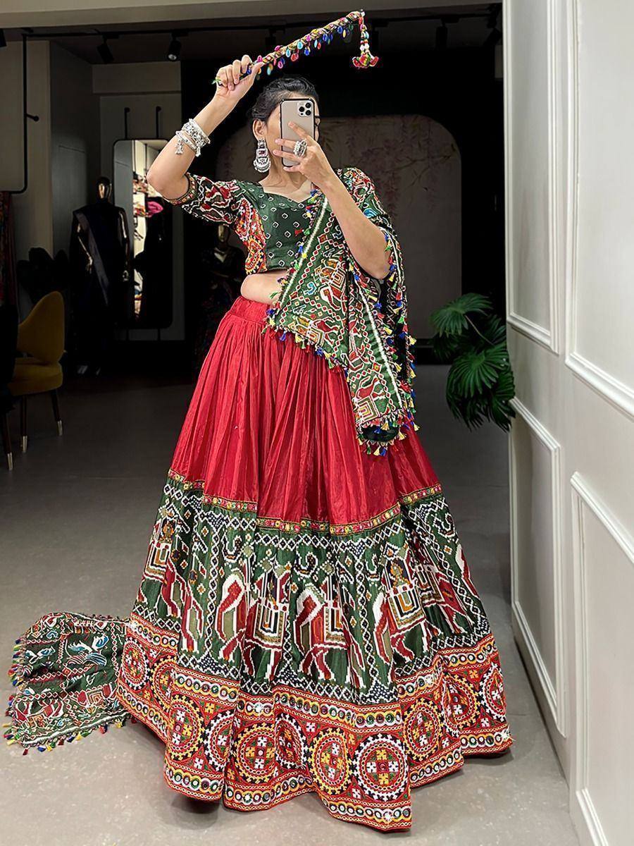 Vibrant red and green embroidered lehenga choli with mirror work, perfect for Indian ethnic occasions.