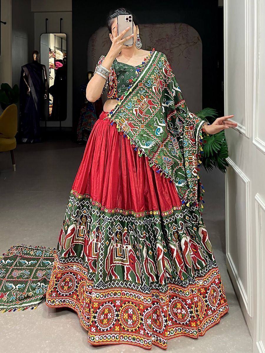 Vibrant red and green embroidered lehenga choli with mirror work, perfect for Indian ethnic wear occasions.