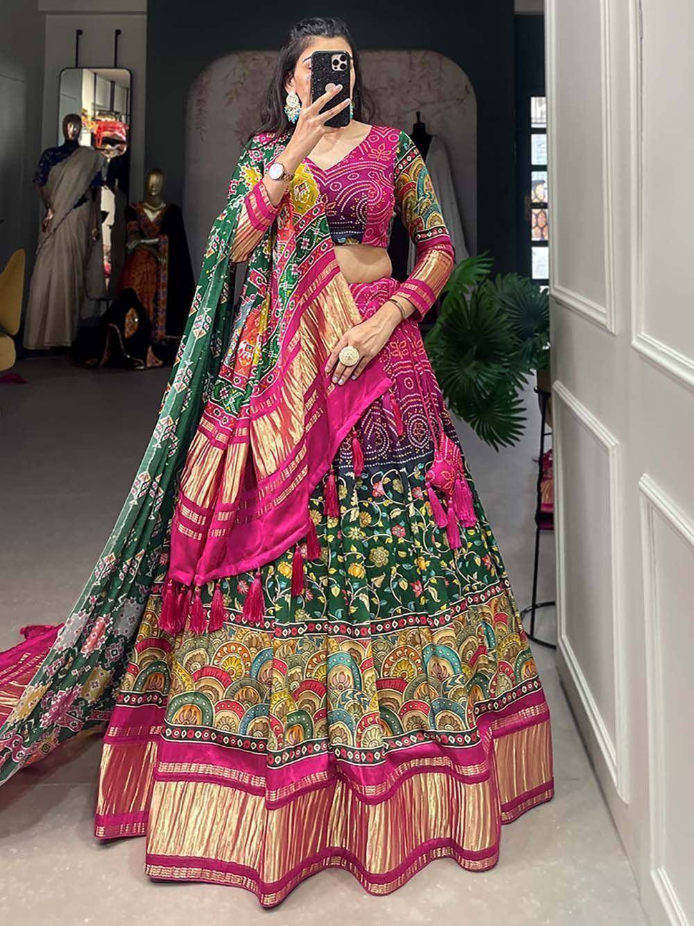 Vibrant pink and green designer lehenga choli with intricate floral prints and tassels, perfect for ethnic occasions.