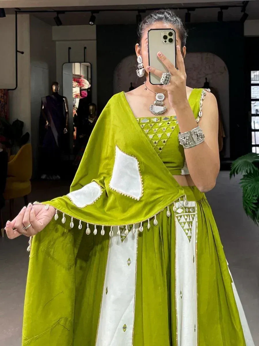 Green and white ethnic lehenga choli with mirror work and pearl detailing, perfect for Indian weddings or festive occasions.