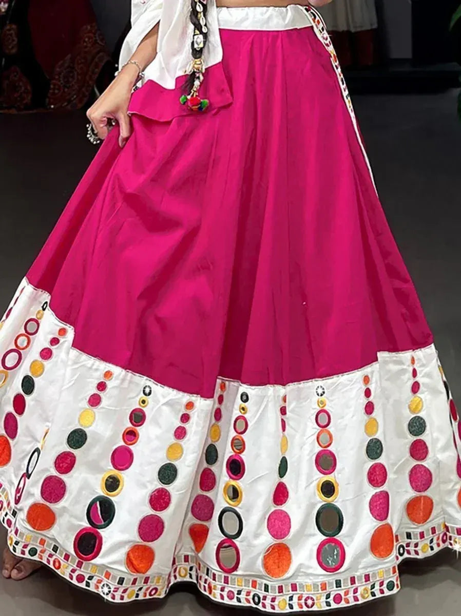 Vibrant pink and white ethnic lehenga with colorful mirror and embroidery work, perfect for Indian celebrations.