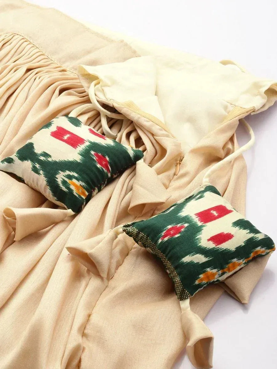 Beige ethnic gown with green red ikat patterned cushions, perfect for Indian wear styling