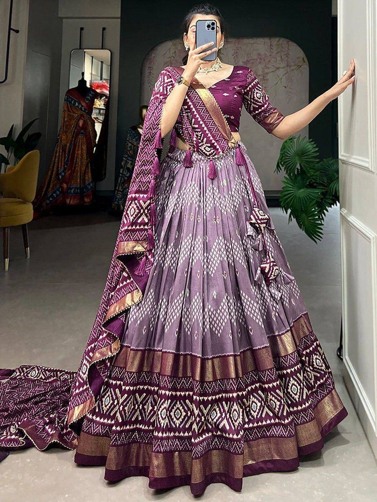 Purple ethnic lehenga choli with geometric print, tassels, and gold border, perfect for weddings or festivals