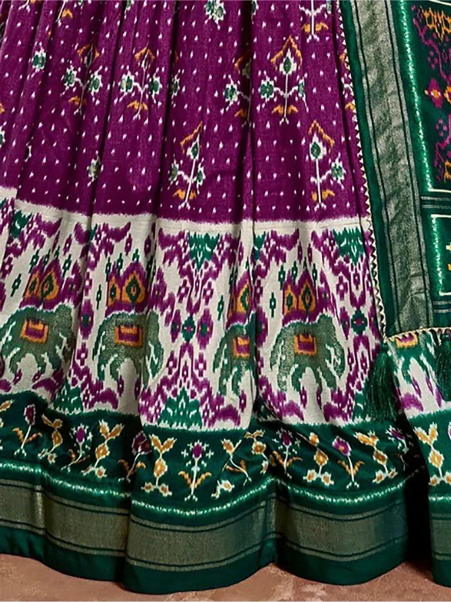 Purple and green ethnic lehenga with elephant print and ikat patterns, ideal for Indian weddings and festivals.