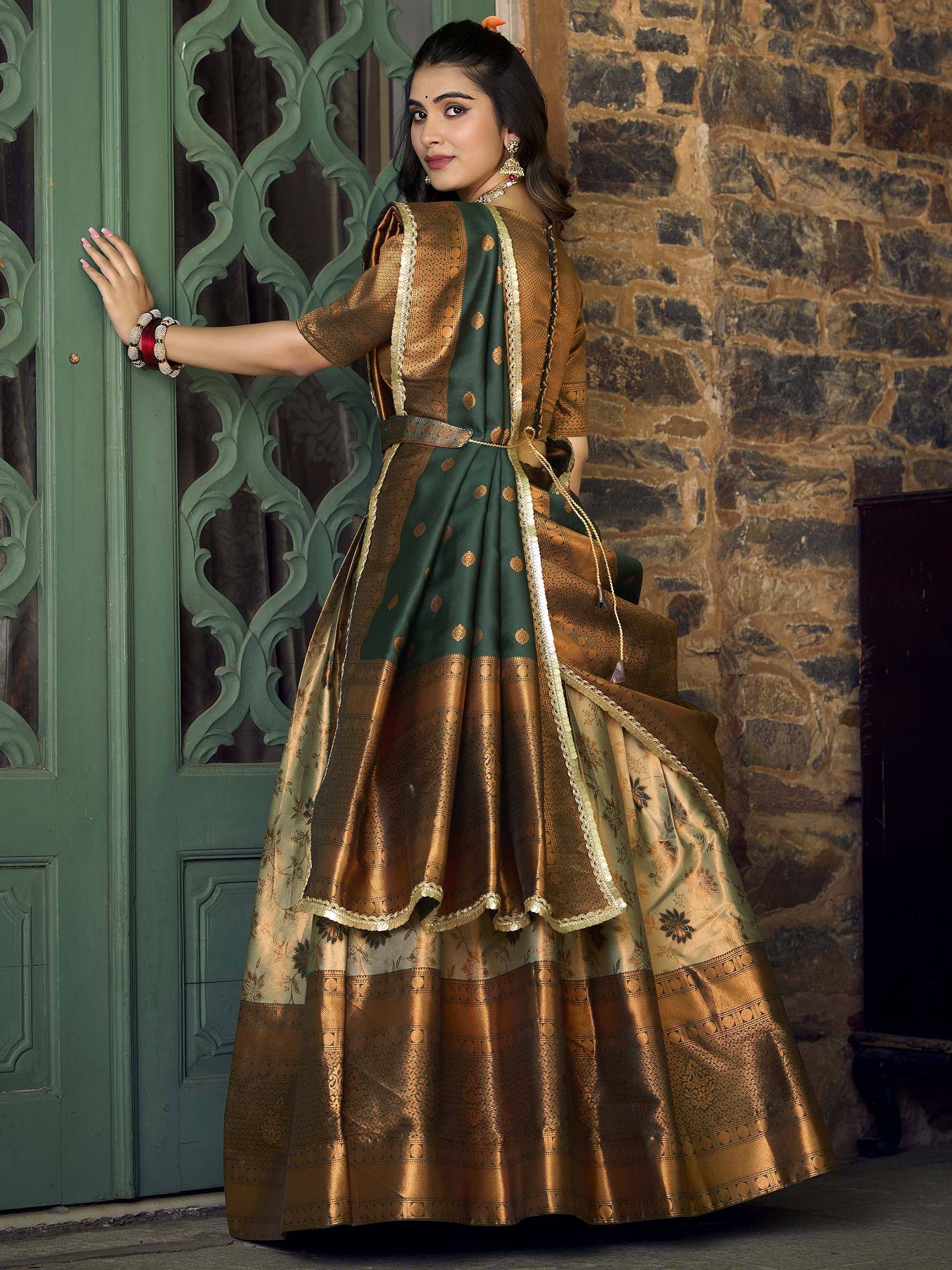 Woman in green and gold designer lehenga choli with intricate embroidery, standing by ornate door