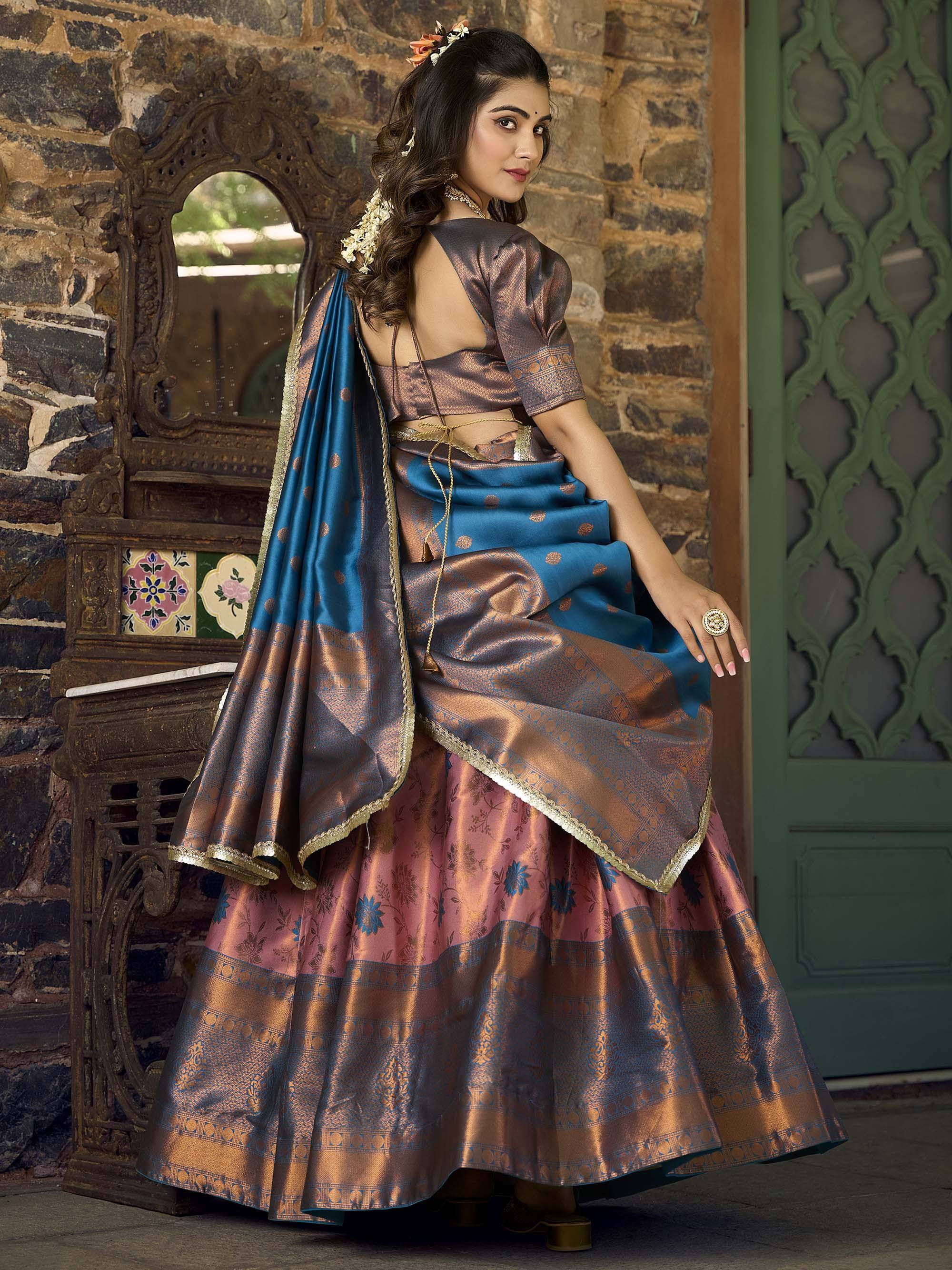 Woman in designer lehenga choli with blue and bronze silk, floral motifs, gold trim, traditional Indian ethnic wear