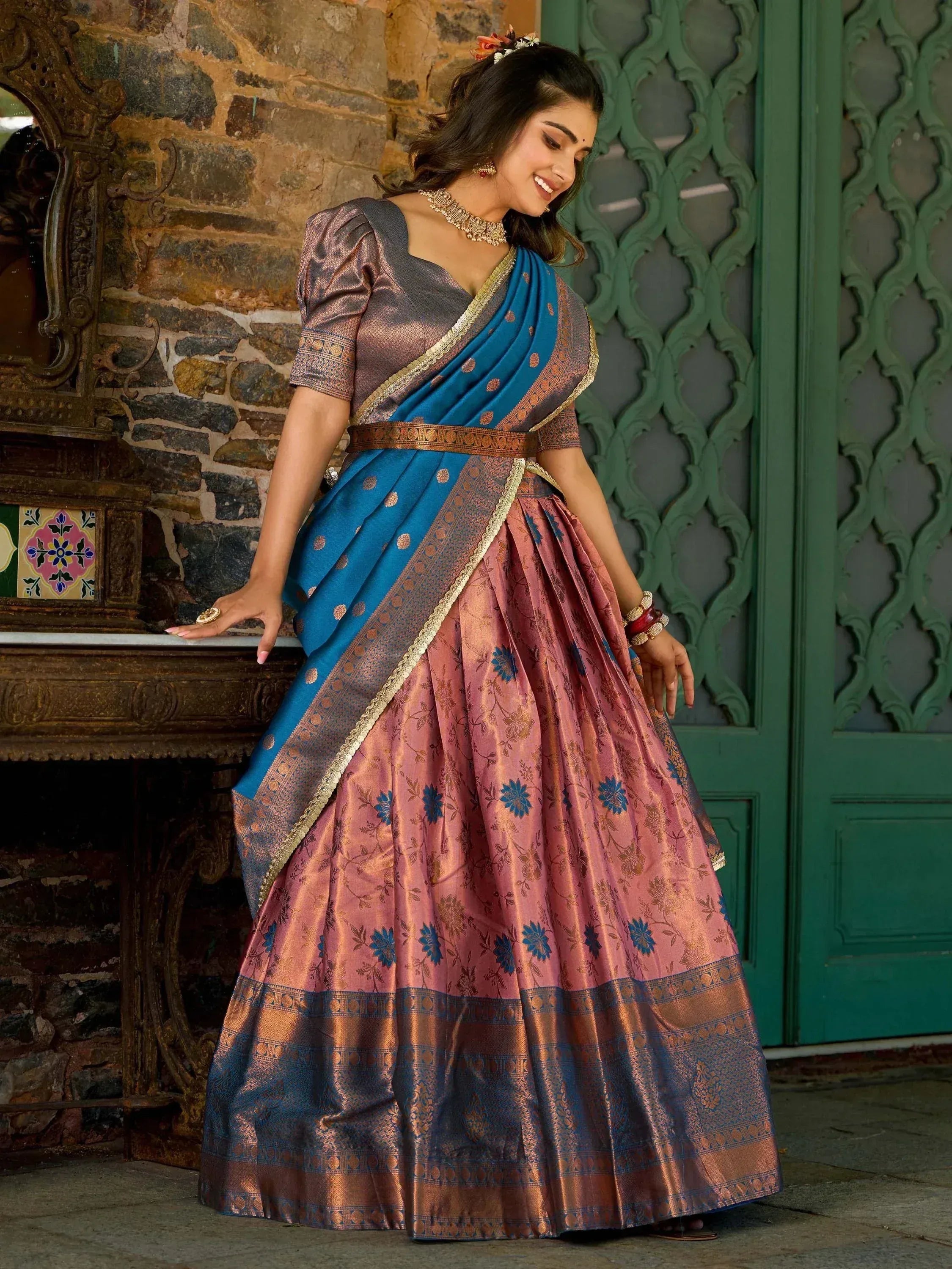 Woman in elegant blue and pink floral lehenga choli with gold trim, traditional Indian ethnic wear