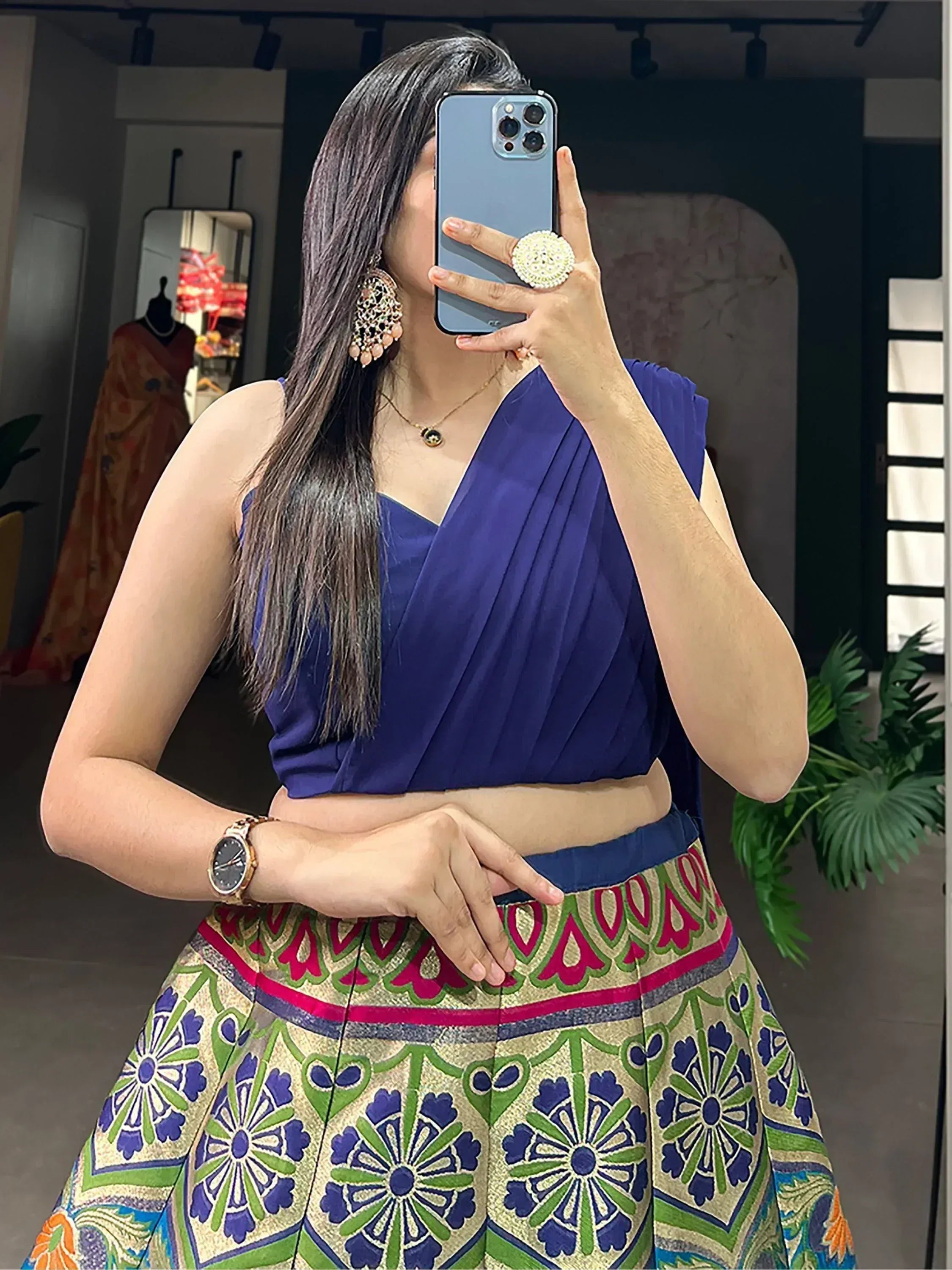 Woman in blue pleated crop top with colorful printed skirt, ethnic wear outfit