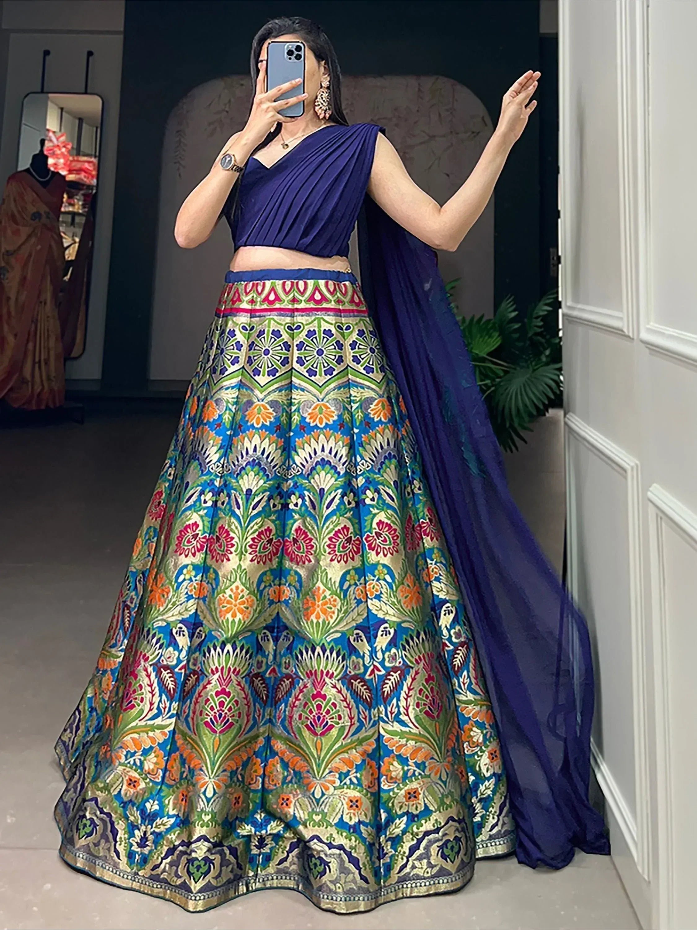 Woman in vibrant floral lehenga choli with blue dupatta, Indian ethnic wear for weddings and parties
