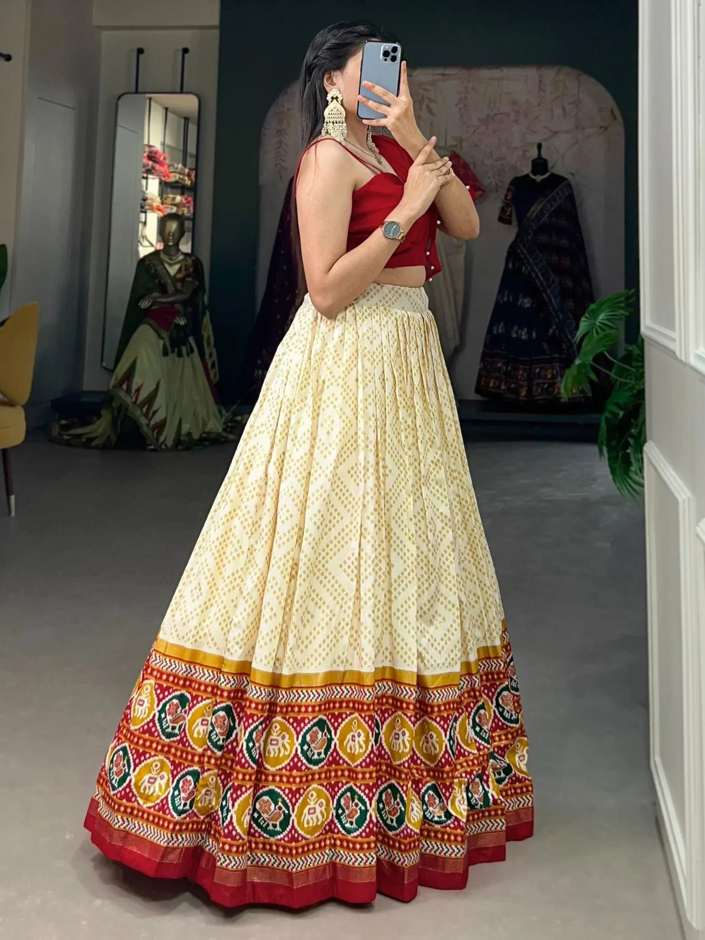 Woman in red crop top and cream lehenga with elephant print border, Indian ethnic wear