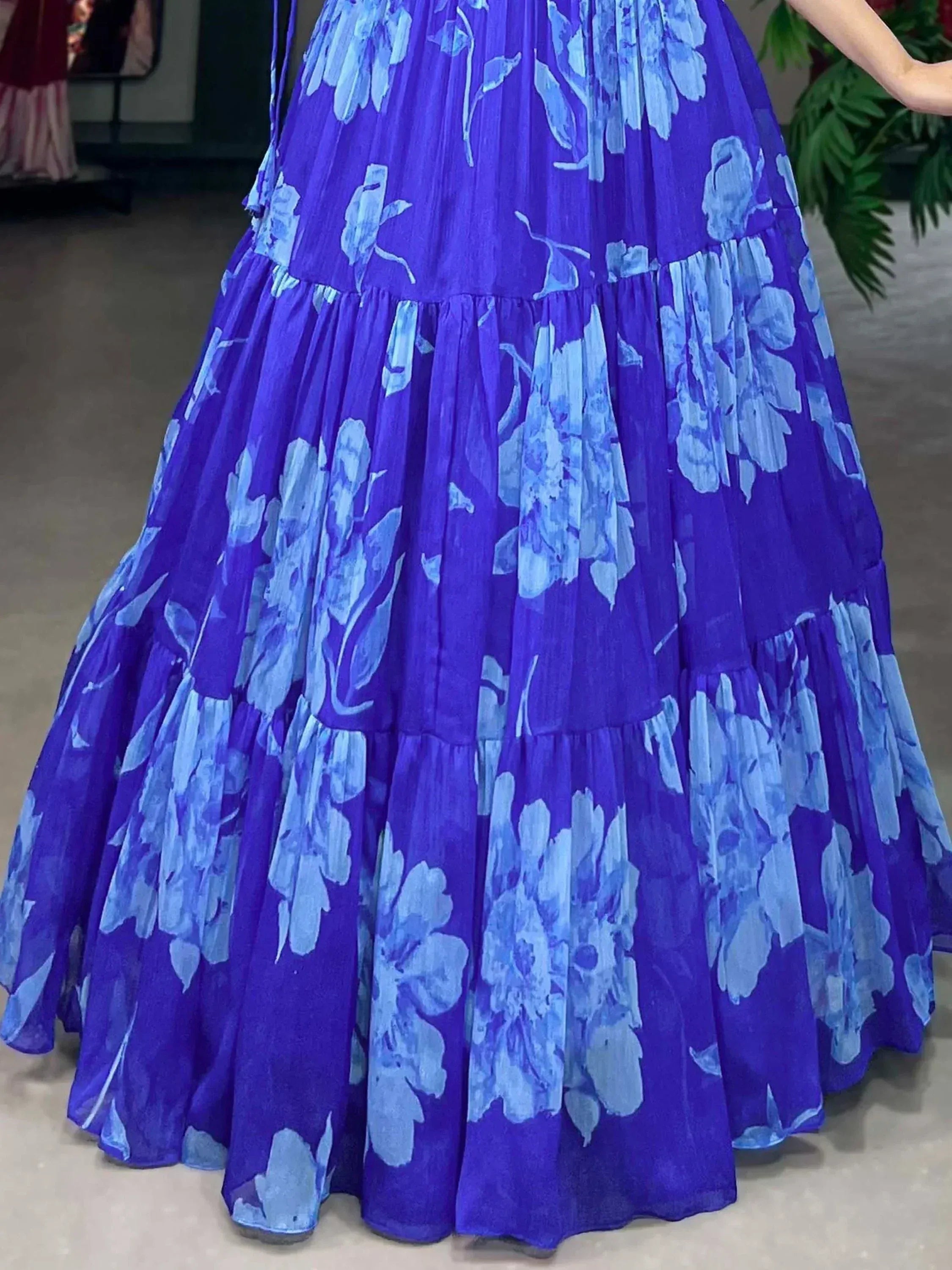 Vibrant blue floral print tiered ethnic gown with flowing pleats, perfect for festive occasions.