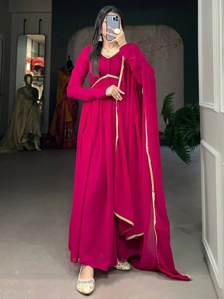 Fuchsia ethnic gown with gold trim, long sleeves, and matching dupatta for Indian wear