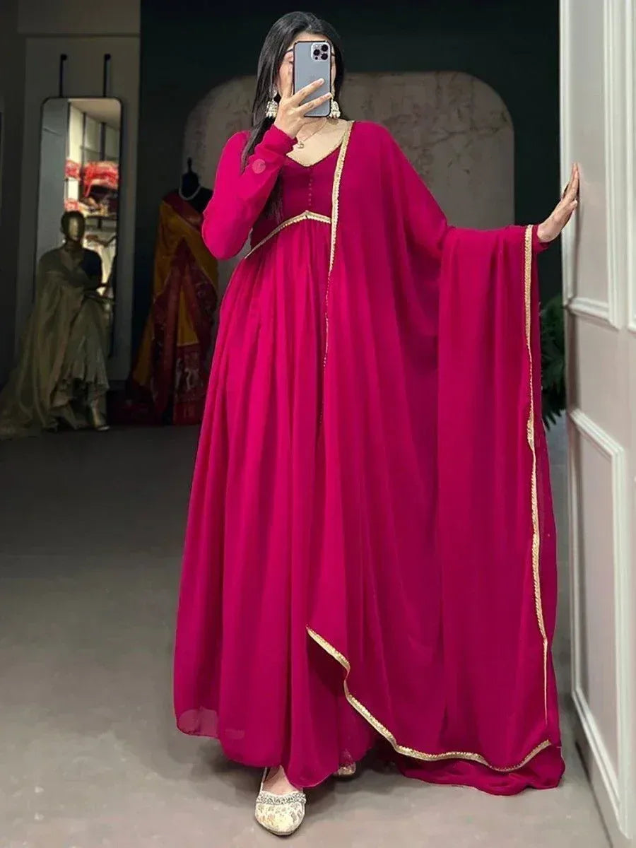Vibrant magenta ethnic gown with gold trim, perfect for Indian occasions and festive wear.