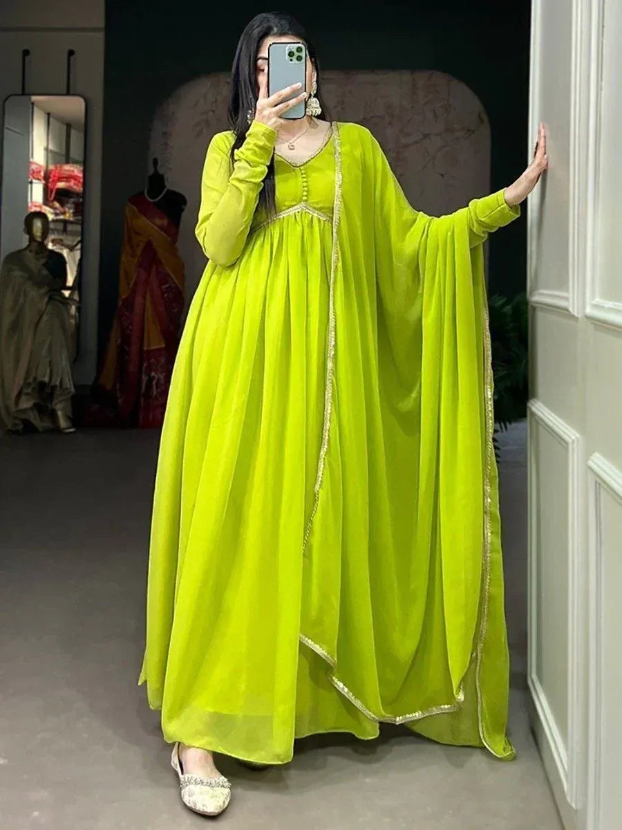 Vibrant lime green ethnic gown with gold trim, long sleeves, and flowing cape-style drape for festive occasions