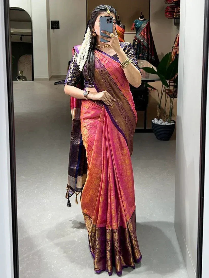 Woman in vibrant pink and purple silk saree with gold border, traditional Indian ethnic wear