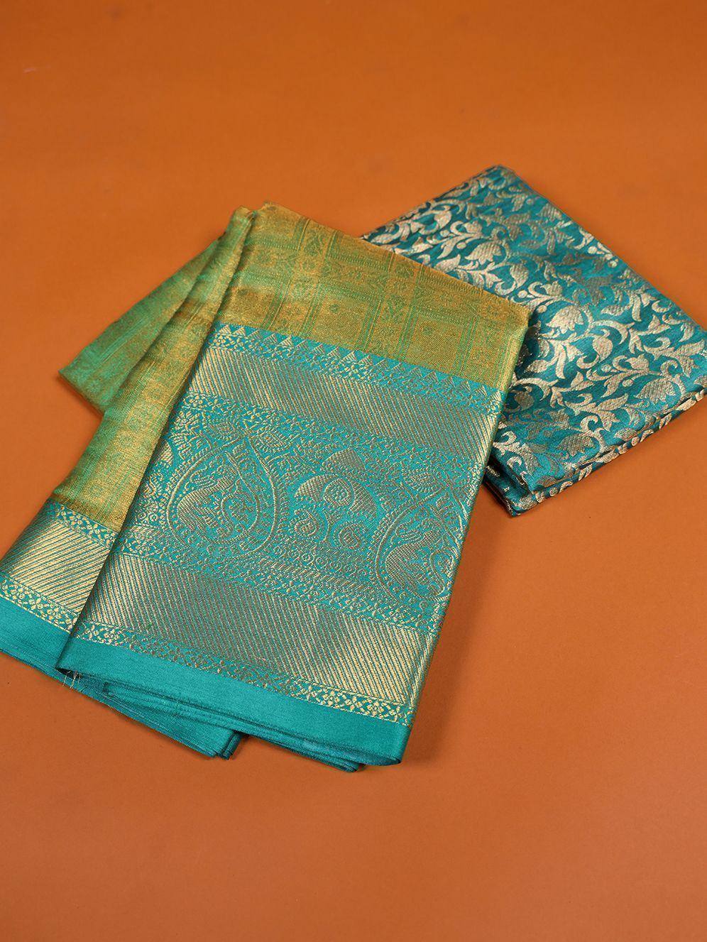 Teal and gold designer saree with intricate paisley and floral brocade patterns, perfect for ethnic wear