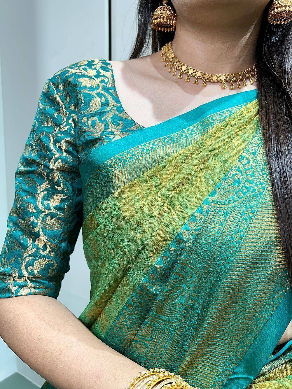 Teal and gold designer saree with intricate embroidery, paired with matching blouse and traditional jewelry