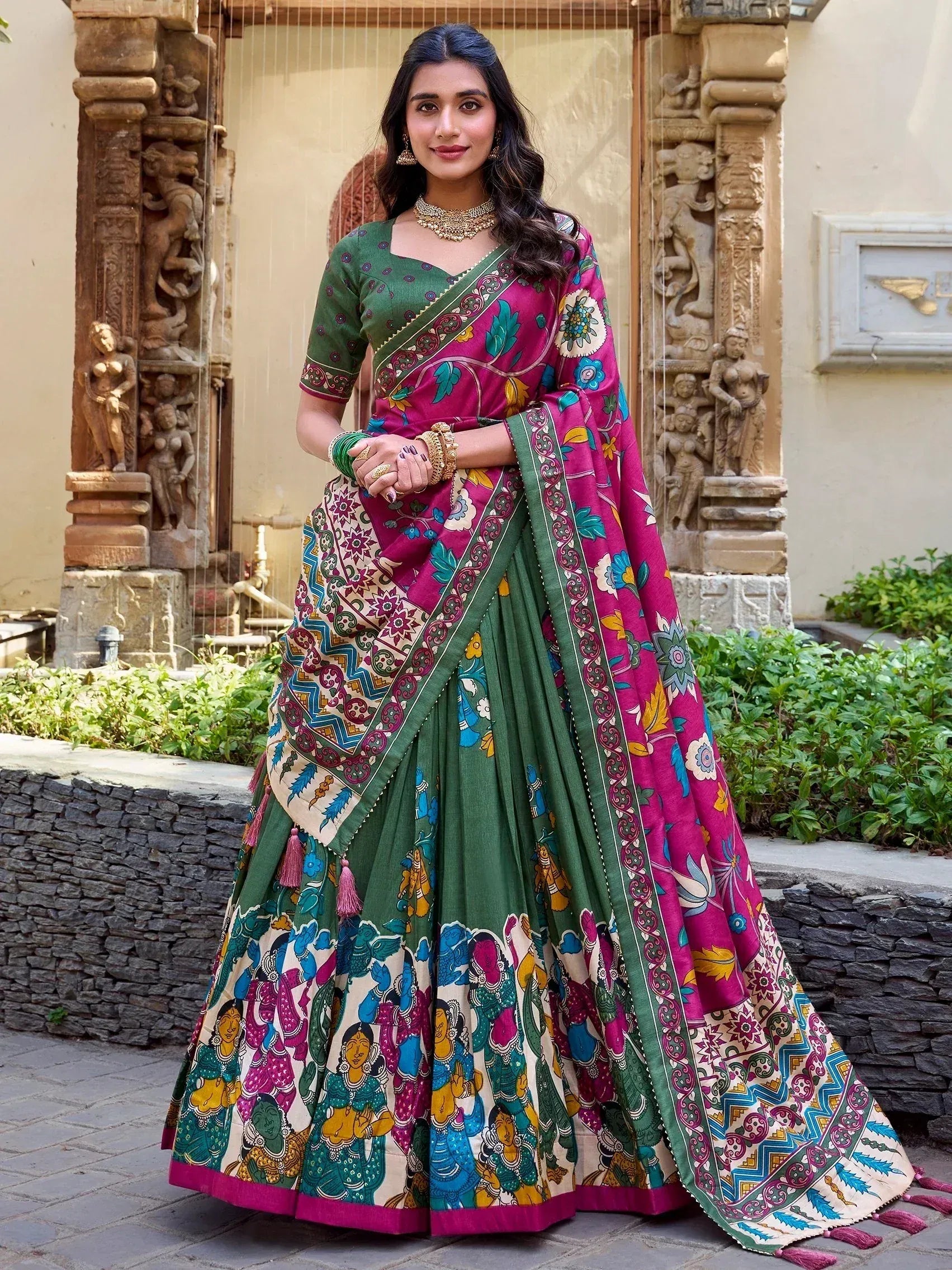 Woman in vibrant green and pink printed lehenga choli with floral and folk art motifs, perfect for Indian ethnic wear.