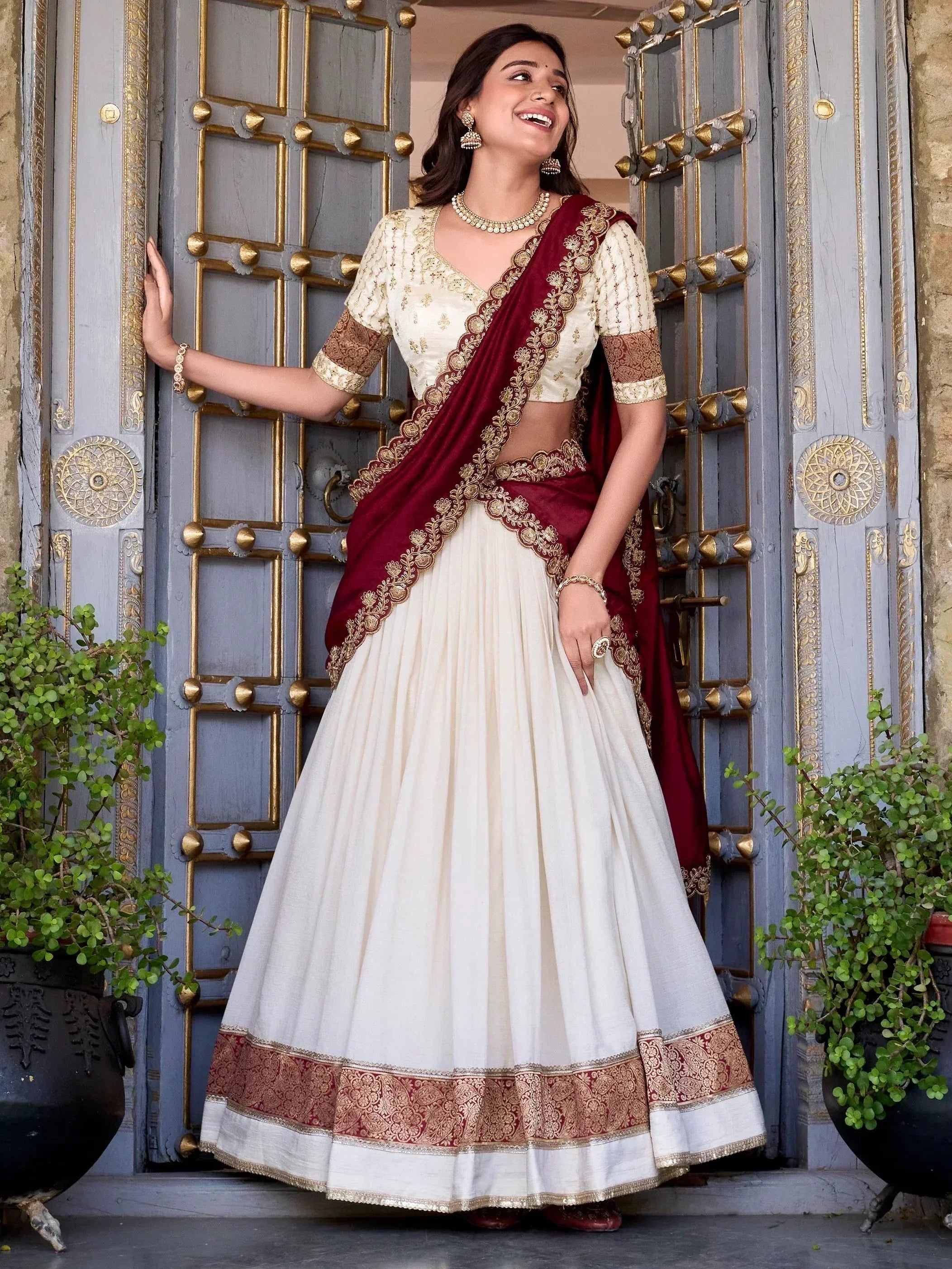 Elegant ivory and maroon lehenga choli with gold embroidery, perfect for Indian ethnic wear occasions.