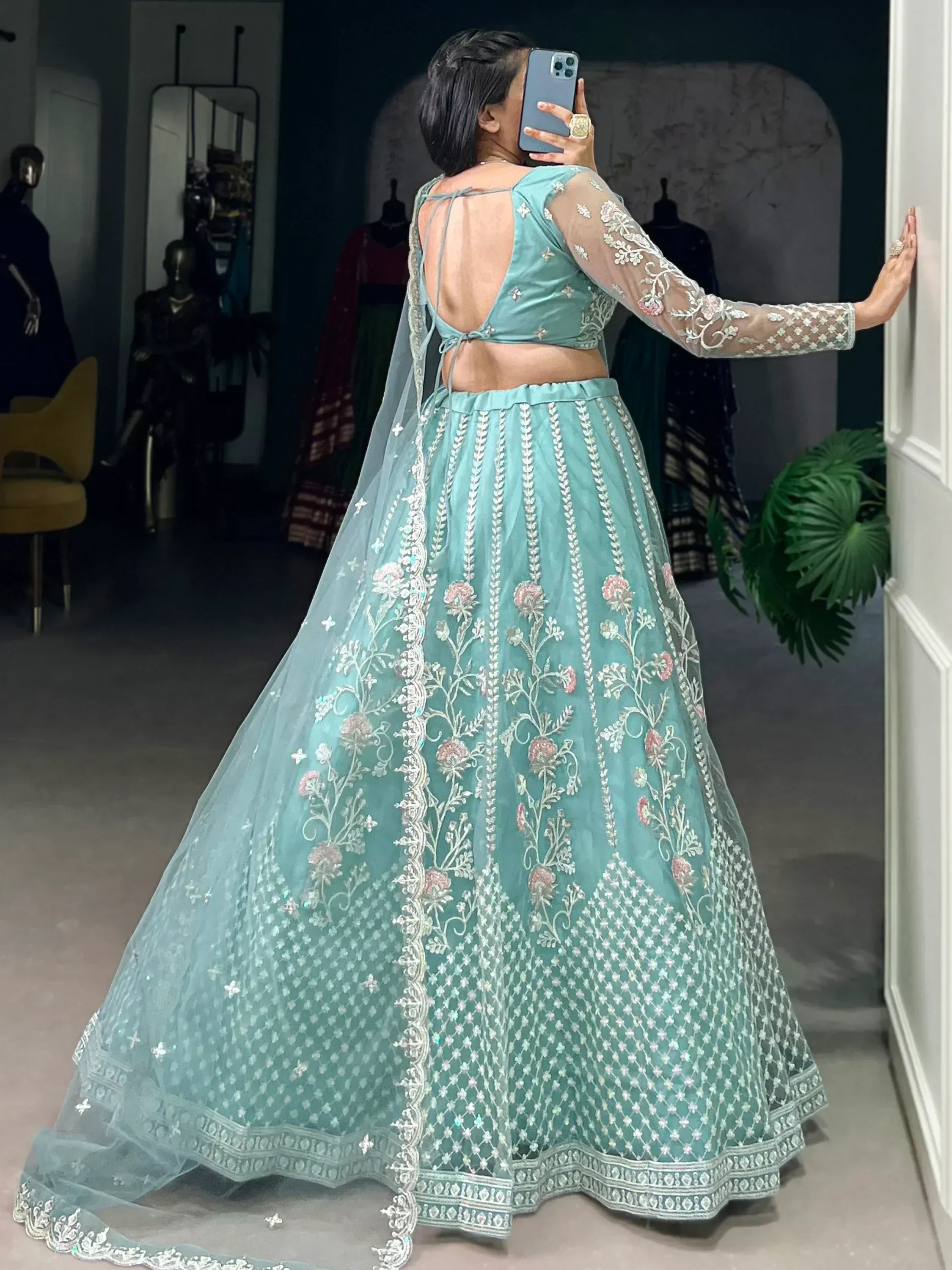 Teal embroidered lehenga choli with sheer sleeves and back tie, perfect for Indian ethnic wear events.
