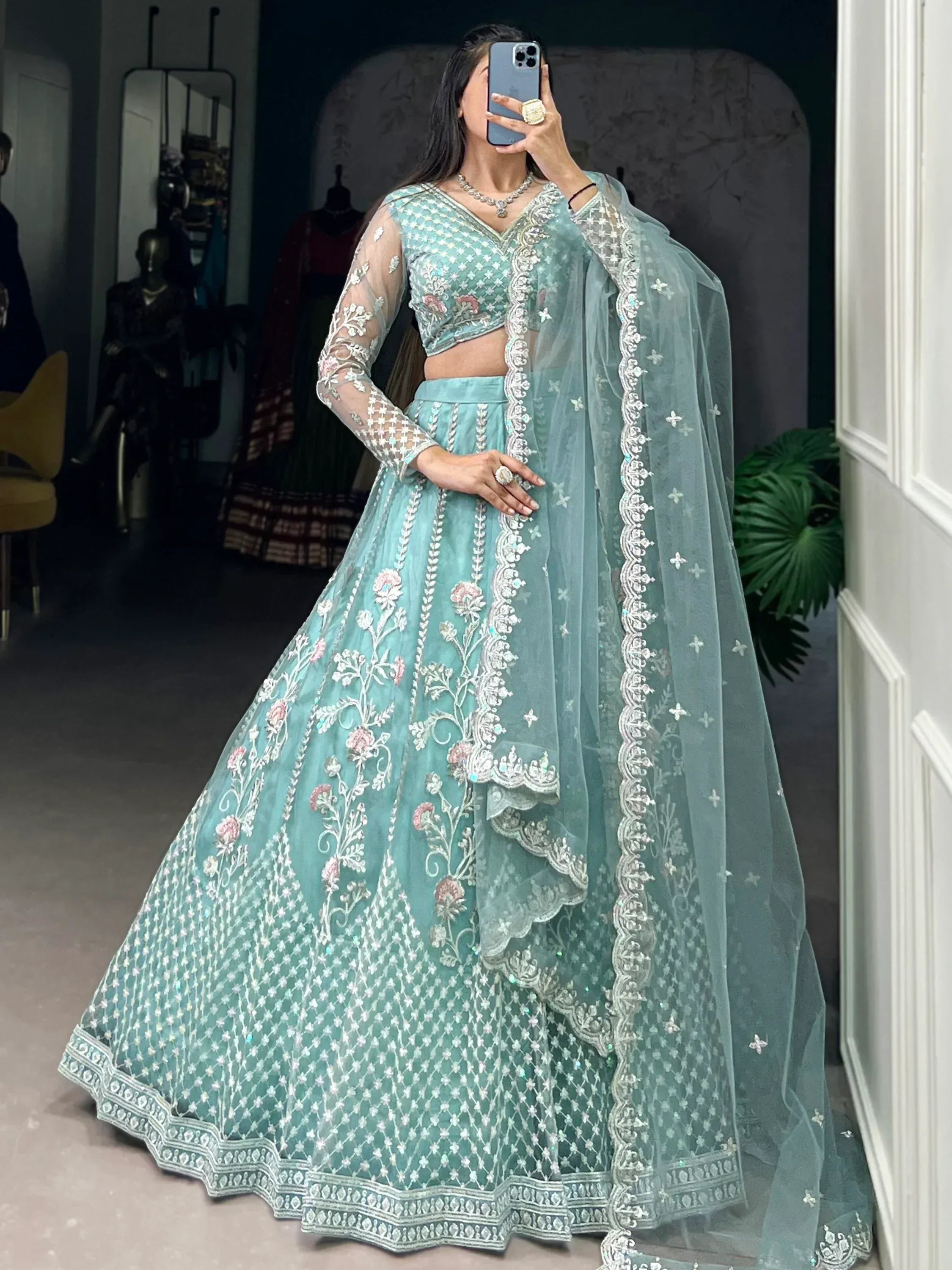 Mint green designer lehenga choli with floral embroidery and sheer dupatta, perfect for Indian ethnic wear occasions.