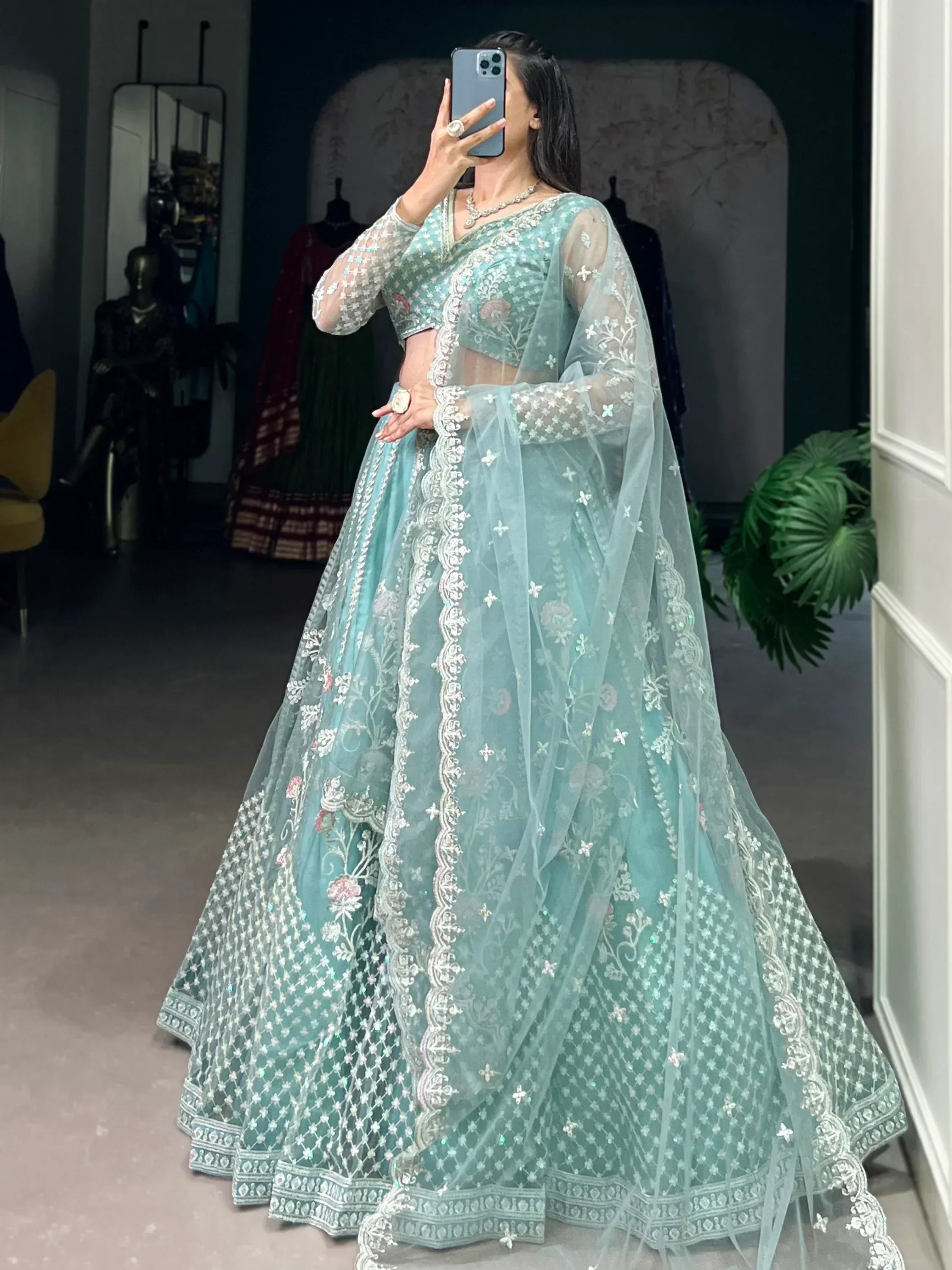 Mint green designer lehenga choli with floral embroidery and sheer dupatta, perfect for weddings and festive occasions.