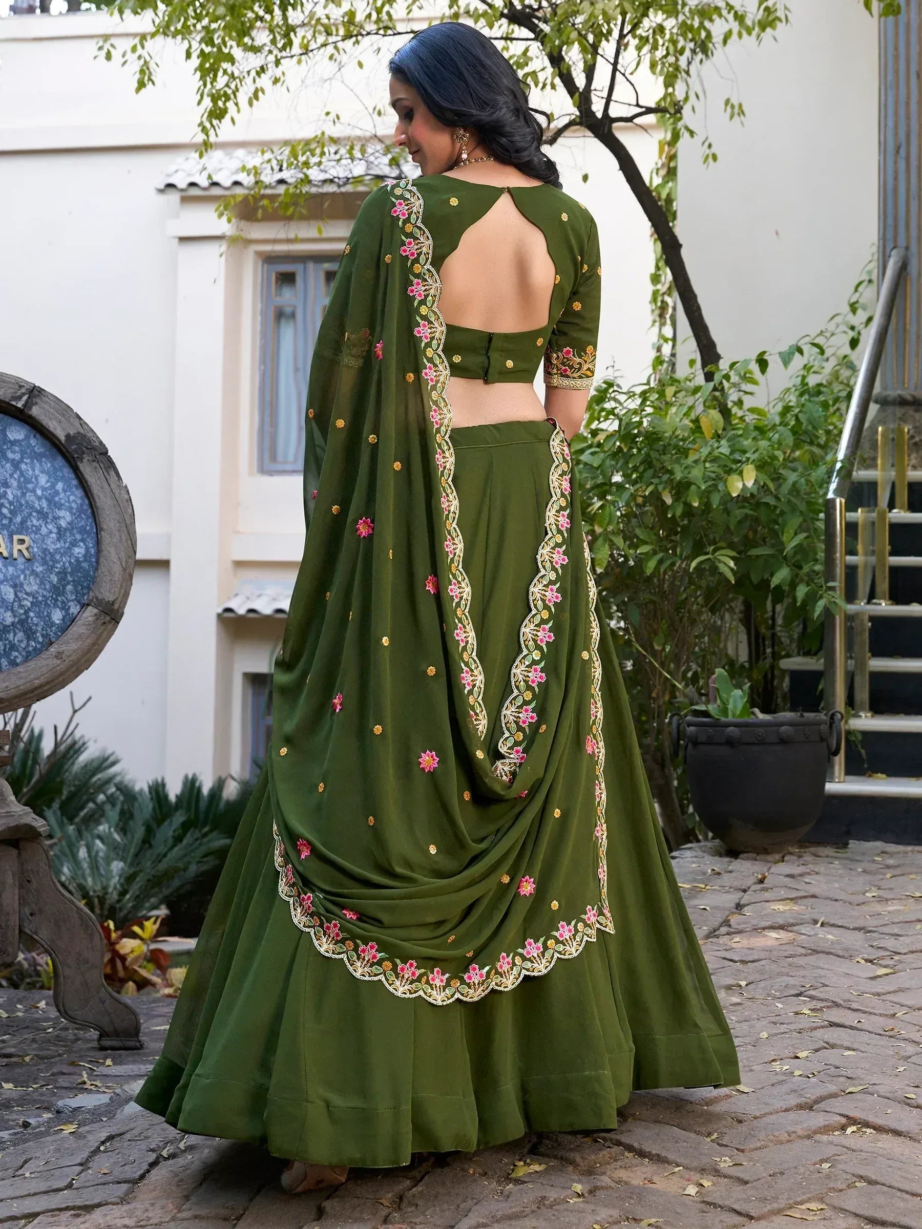 Olive green designer lehenga choli with floral embroidery and open back, perfect for Indian ethnic wear occasions.