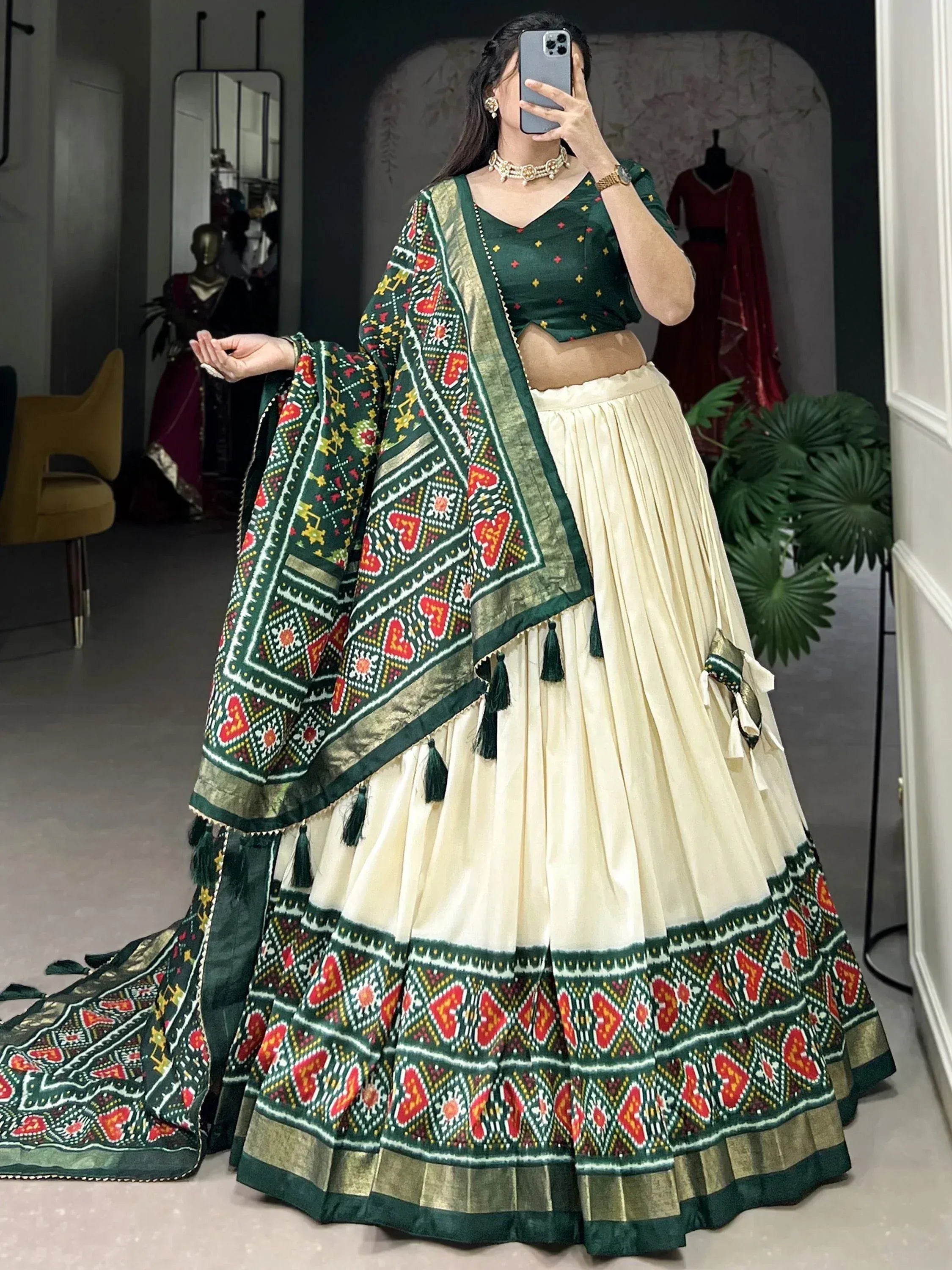 Green and cream ethnic lehenga choli with intricate geometric print and tassels, perfect for Indian occasions.