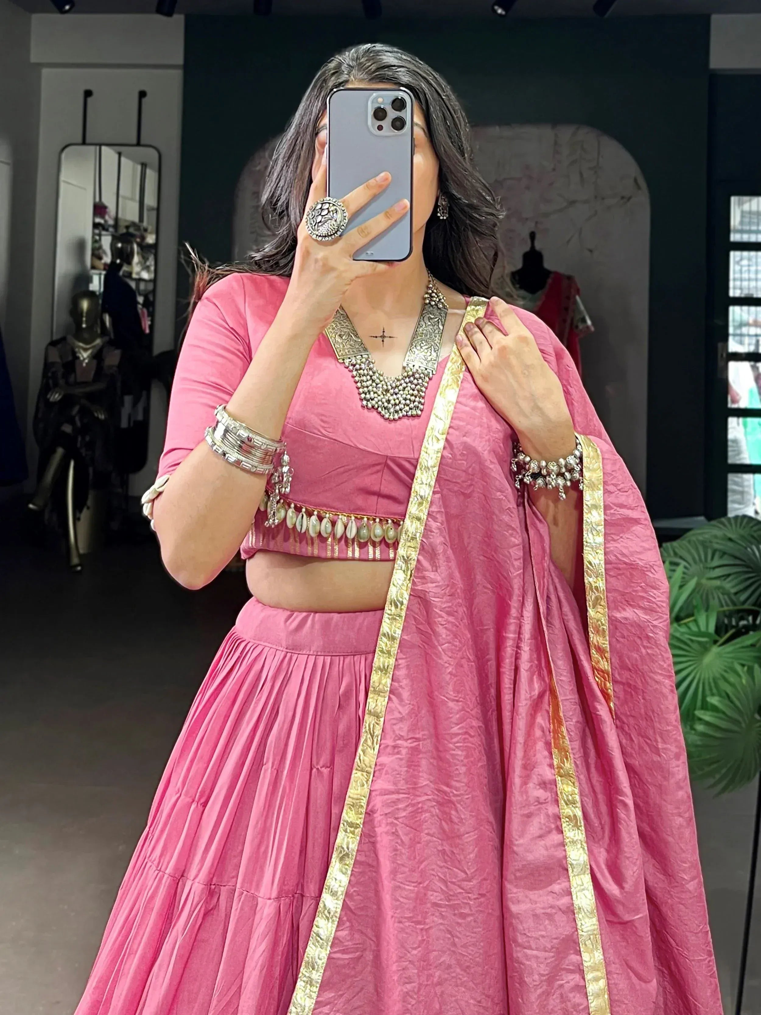 Pink lehenga choli with gold trim and traditional jewelry, perfect for Indian ethnic wear occasions