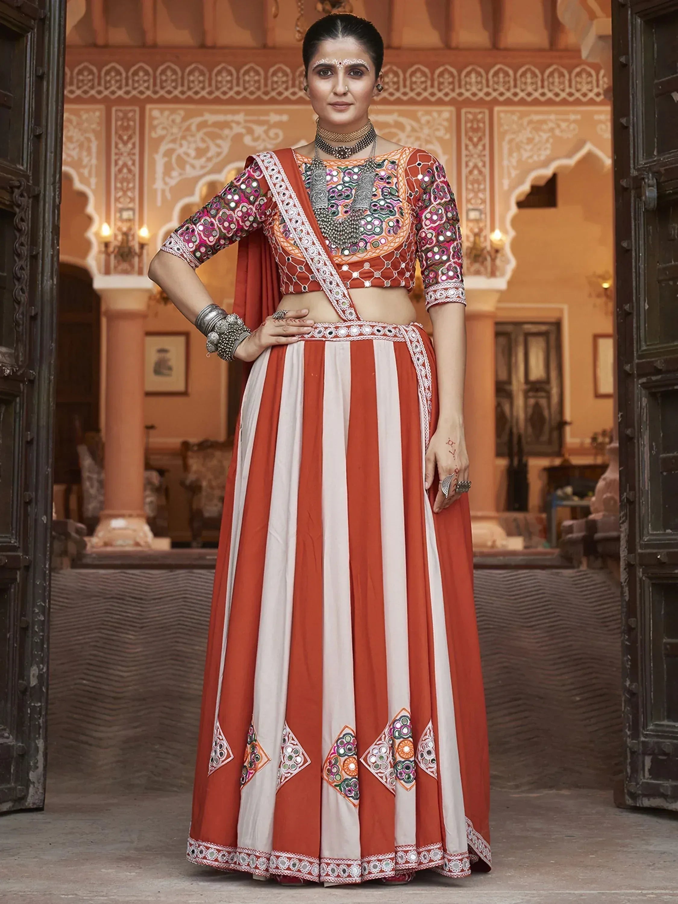 Orange and white striped lehenga choli with mirror work, perfect for Indian ethnic wear occasions.