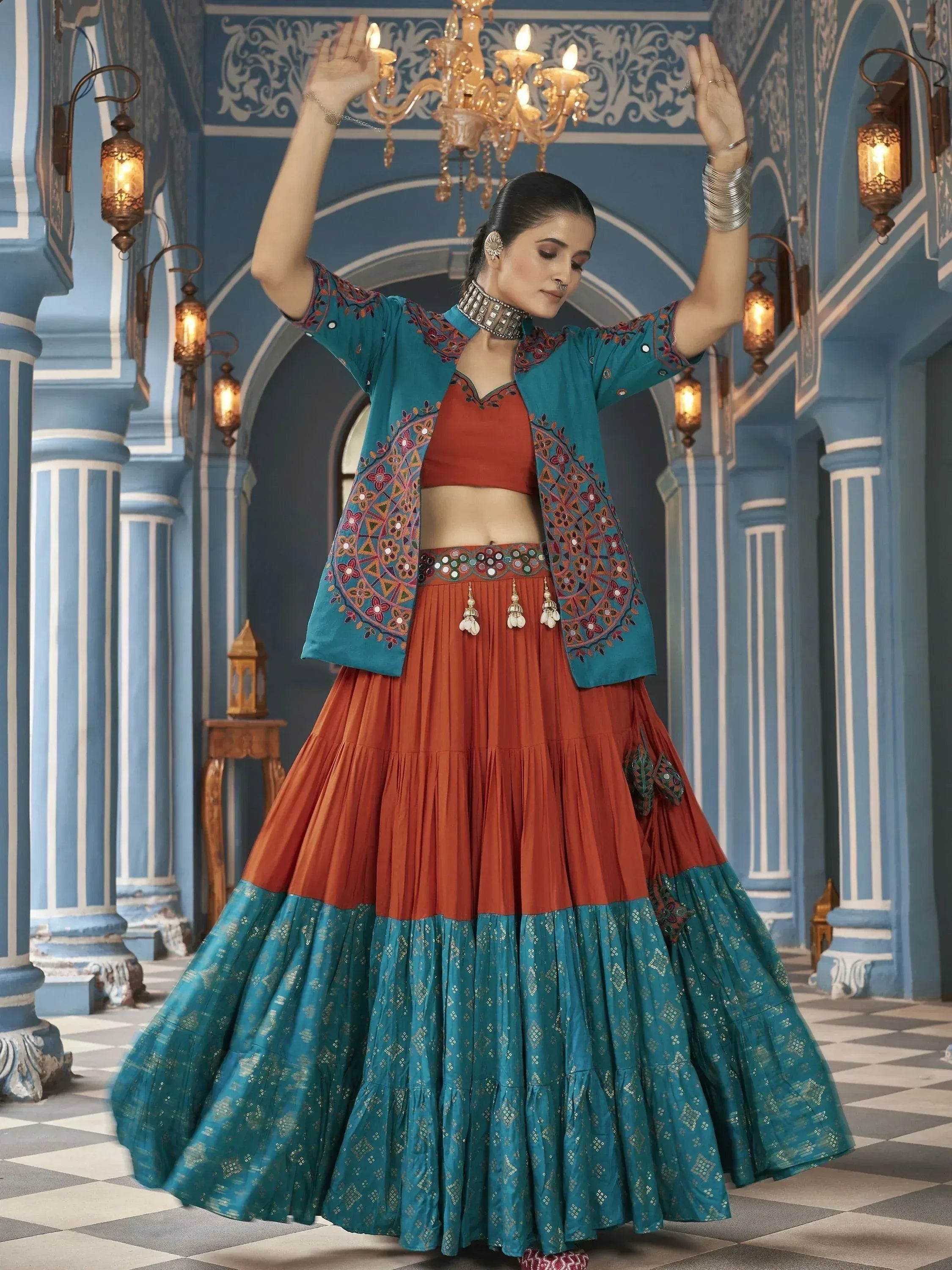Elegant Indian ethnic lehenga choli with teal and rust colors, intricate embroidery, and traditional jewelry.