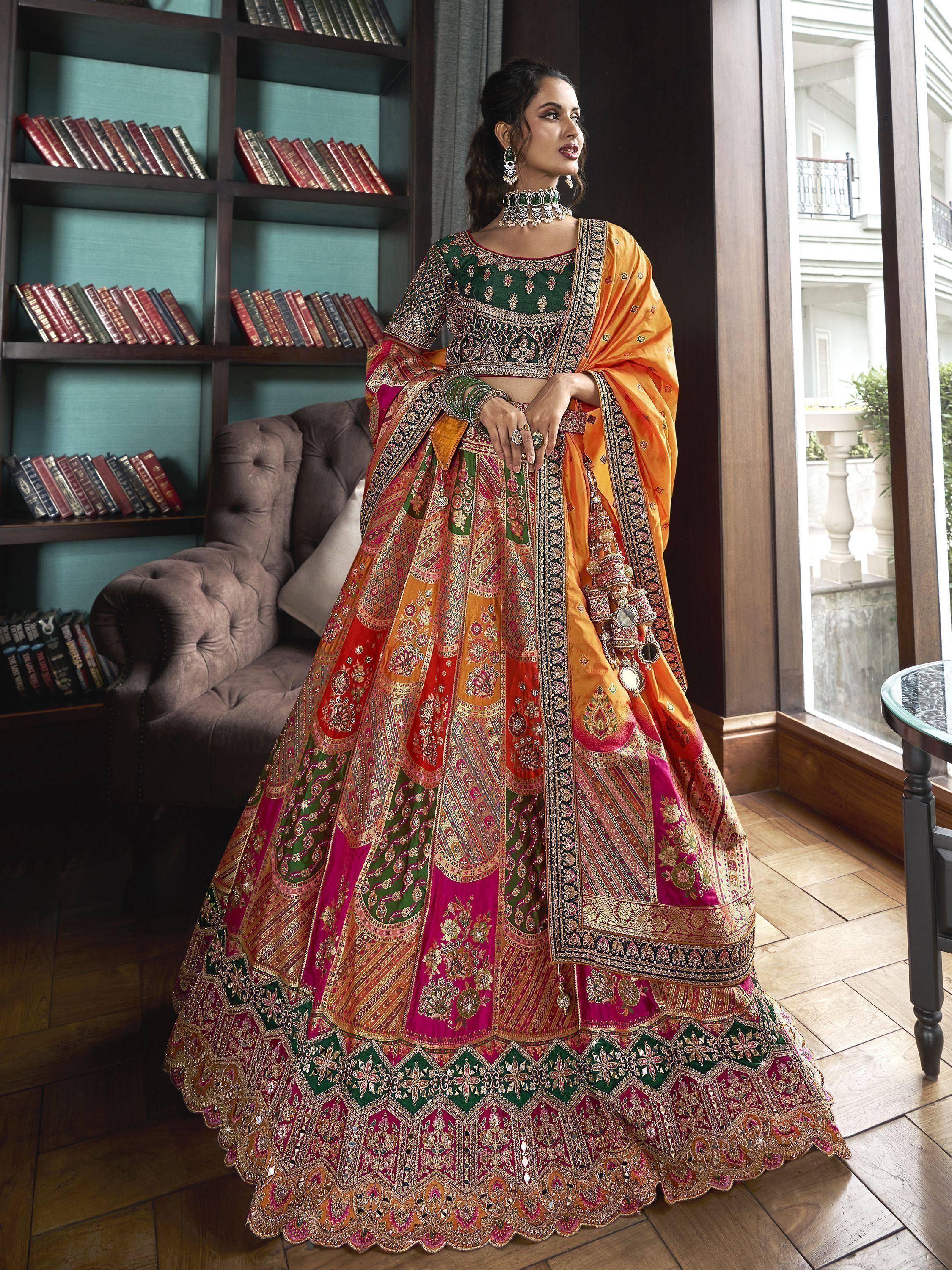 Designer lehenga choli with intricate embroidery in green, orange, and pink, perfect for Indian weddings and festive occasions.