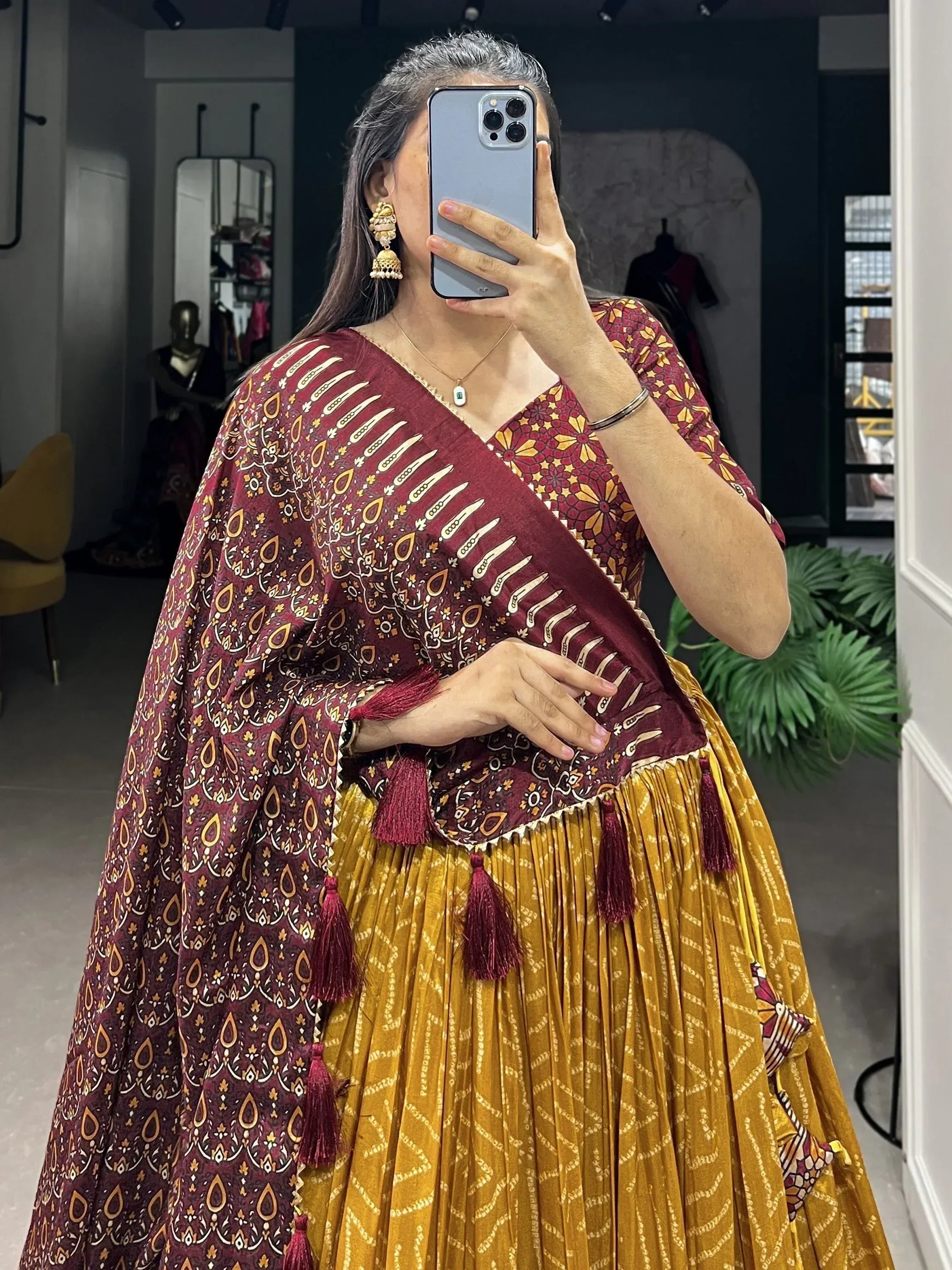 Maroon and mustard printed ethnic lehenga choli with tassels, perfect for Indian festive occasions