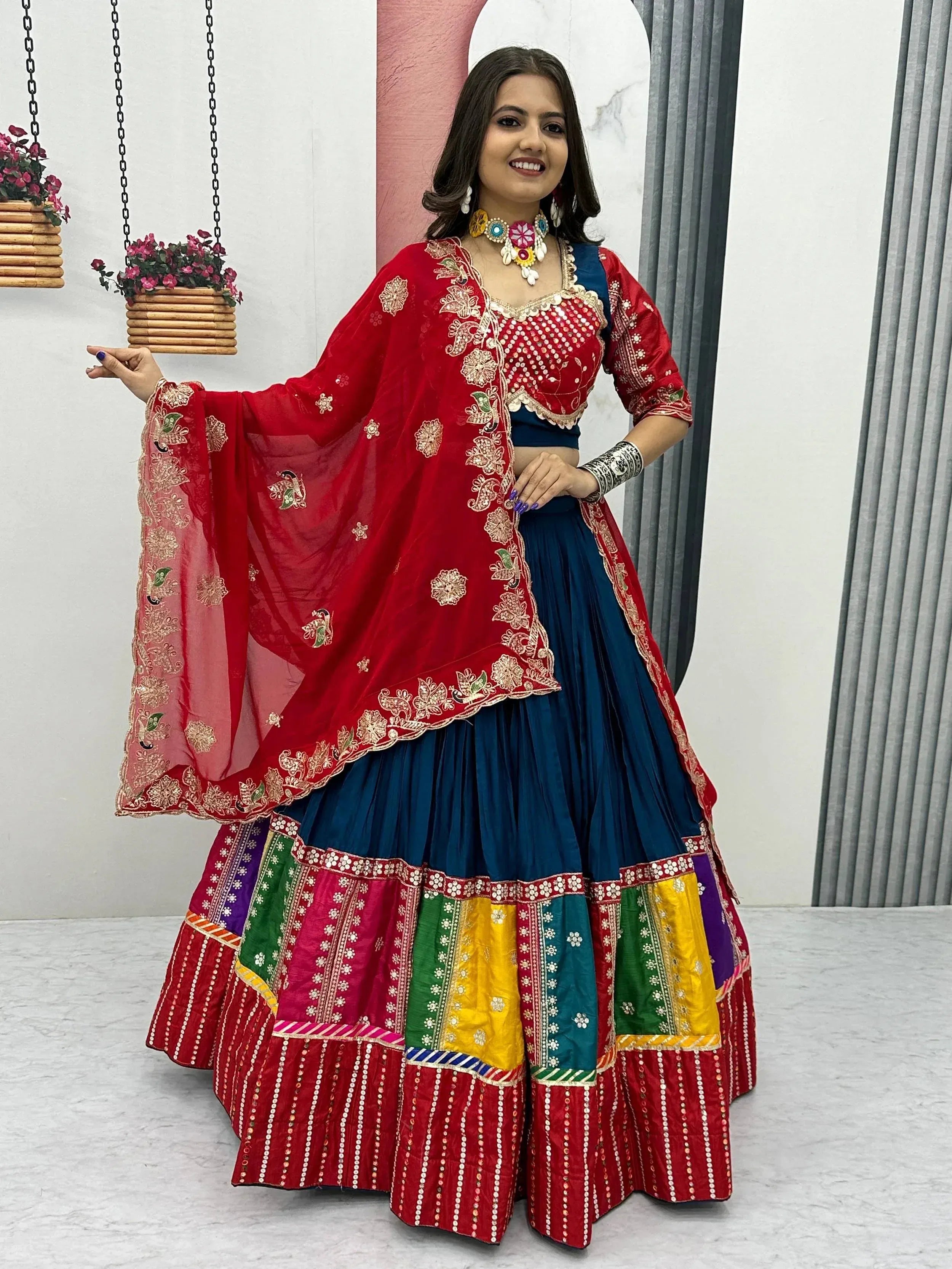 Vibrant red and blue embroidered lehenga choli with colorful patchwork skirt and dupatta, perfect for Indian ethnic wear.