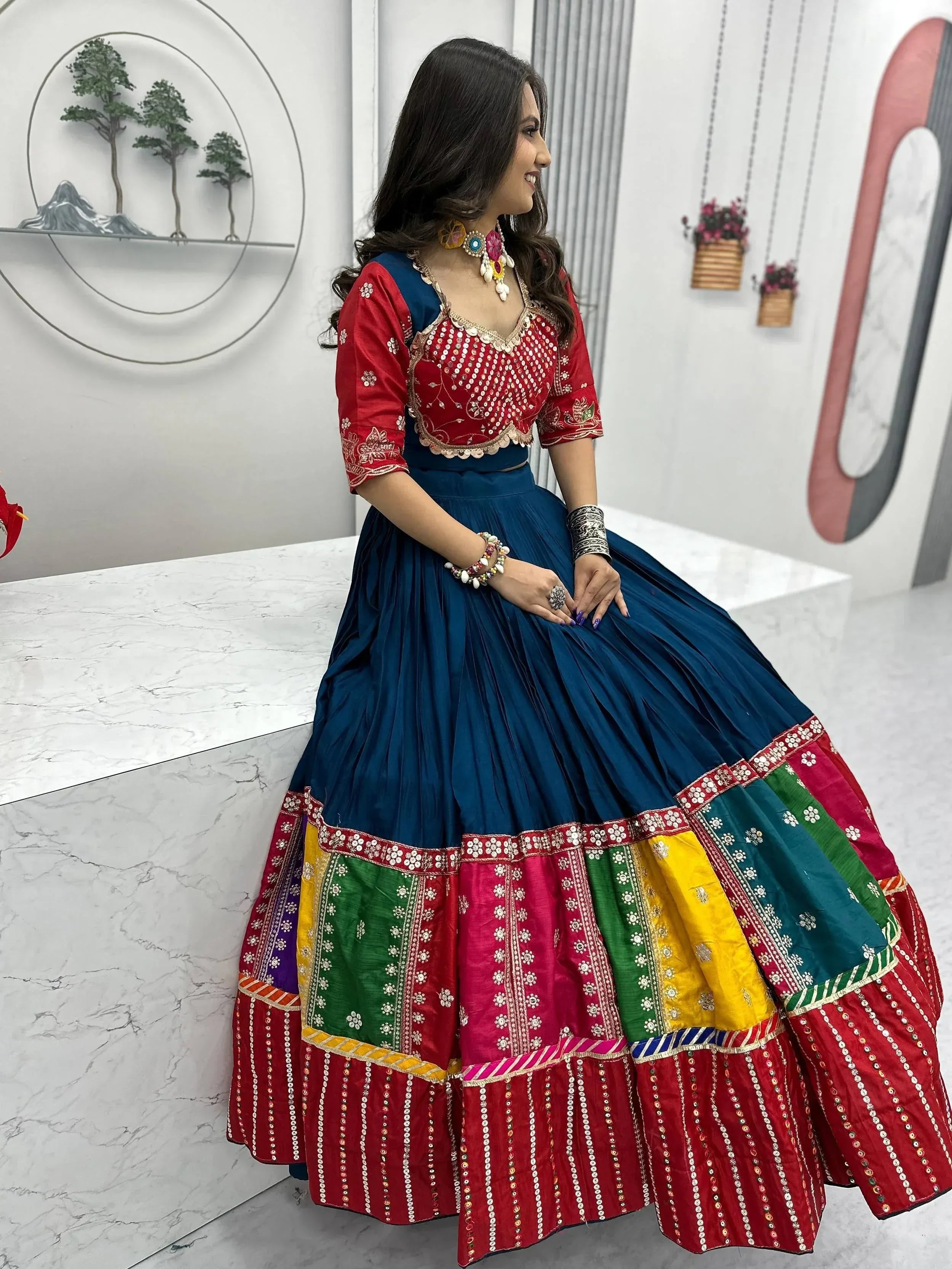 Vibrant red and blue embroidered lehenga choli with colorful patchwork skirt, perfect for Indian ethnic wear.