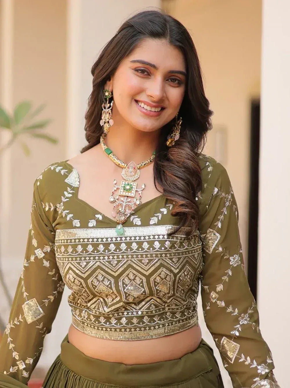 Olive green embroidered lehenga choli with gold detailing and matching jewelry for Indian ethnic wear