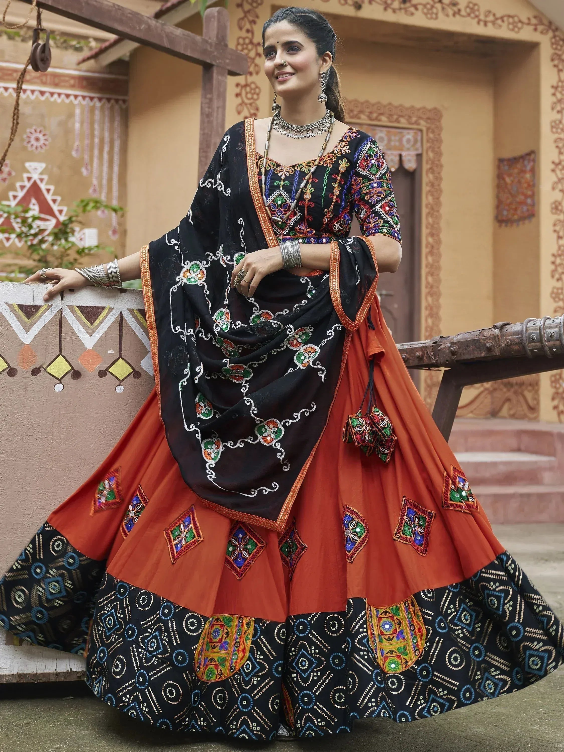 Black and orange embroidered lehenga choli with mirror work, traditional Indian ethnic wear for women