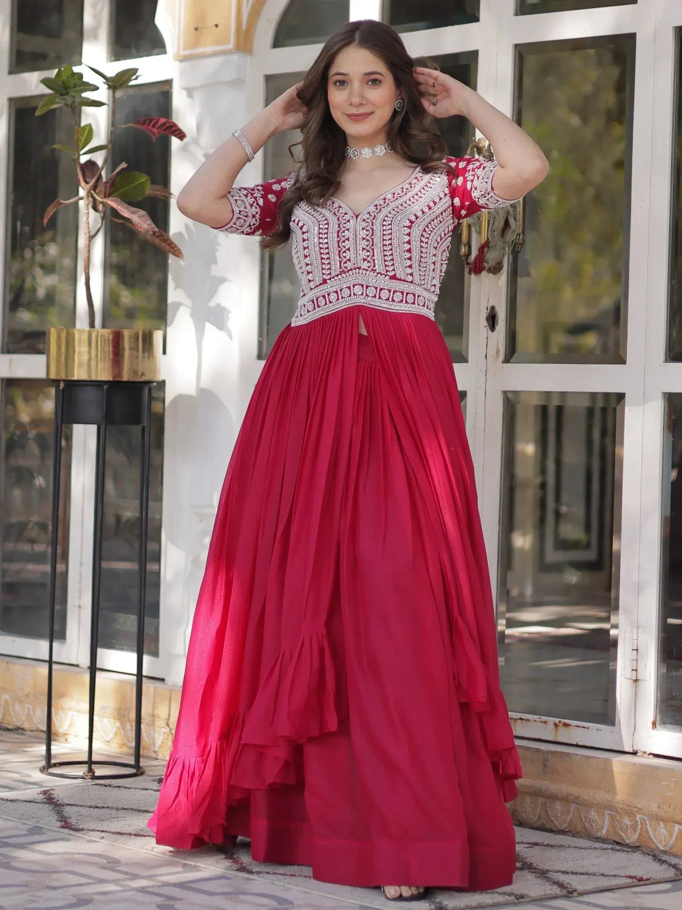 Red ethnic gown with silver embroidery, pleated skirt, and V-neck design for Indian occasions