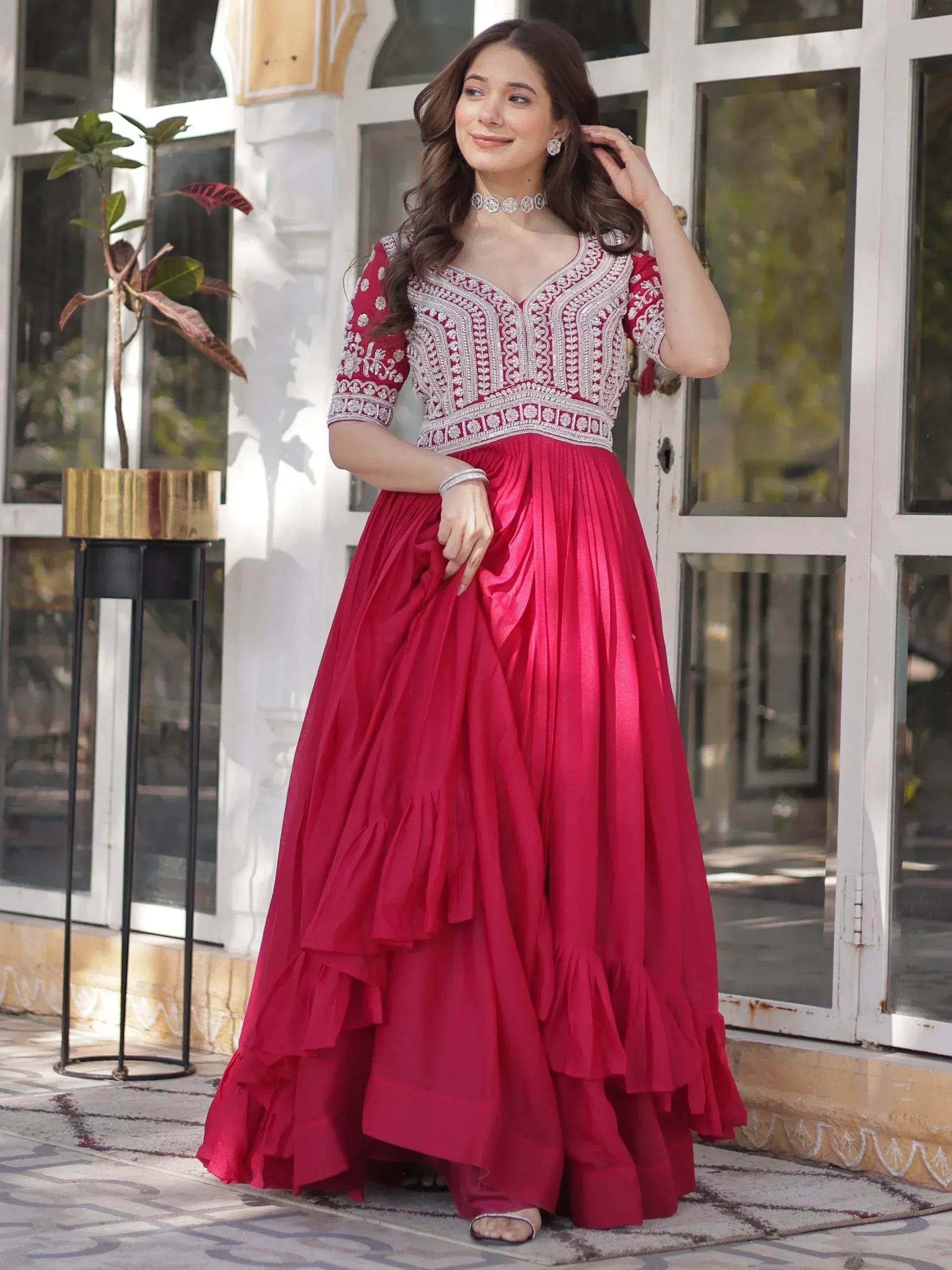Woman in red embroidered ethnic gown with layered skirt, perfect for Indian celebrations and events.