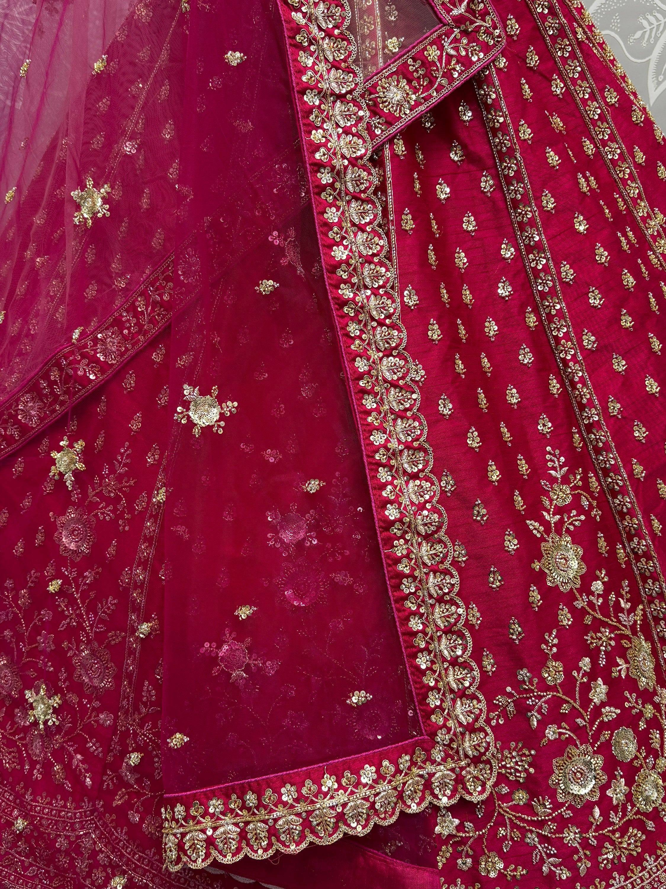 Rich maroon lehenga choli with intricate gold embroidery and sequin work, perfect for Indian weddings and festive occasions.