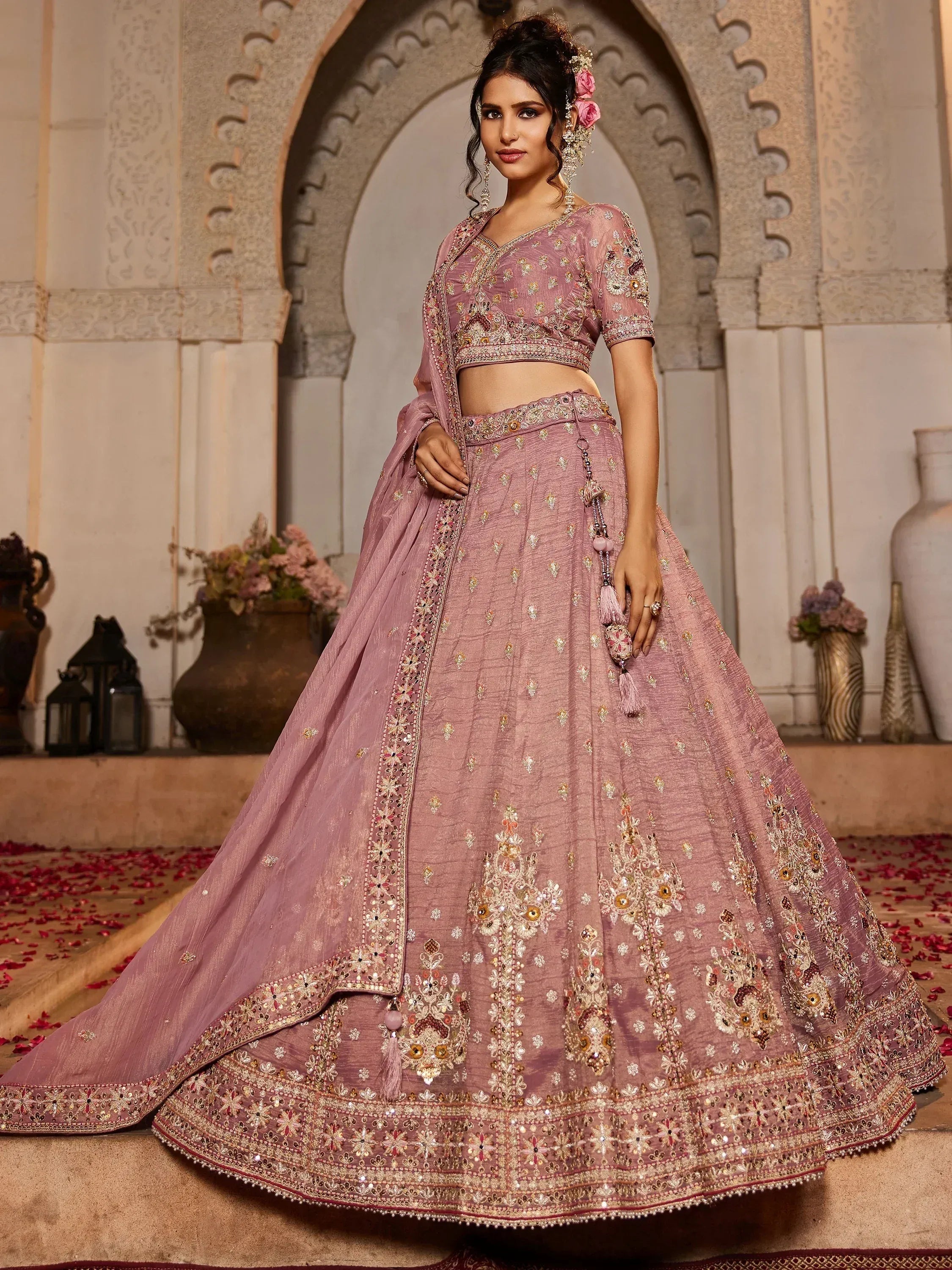 Dusty pink embroidered lehenga choli with floral motifs, perfect for Indian weddings and festive occasions.