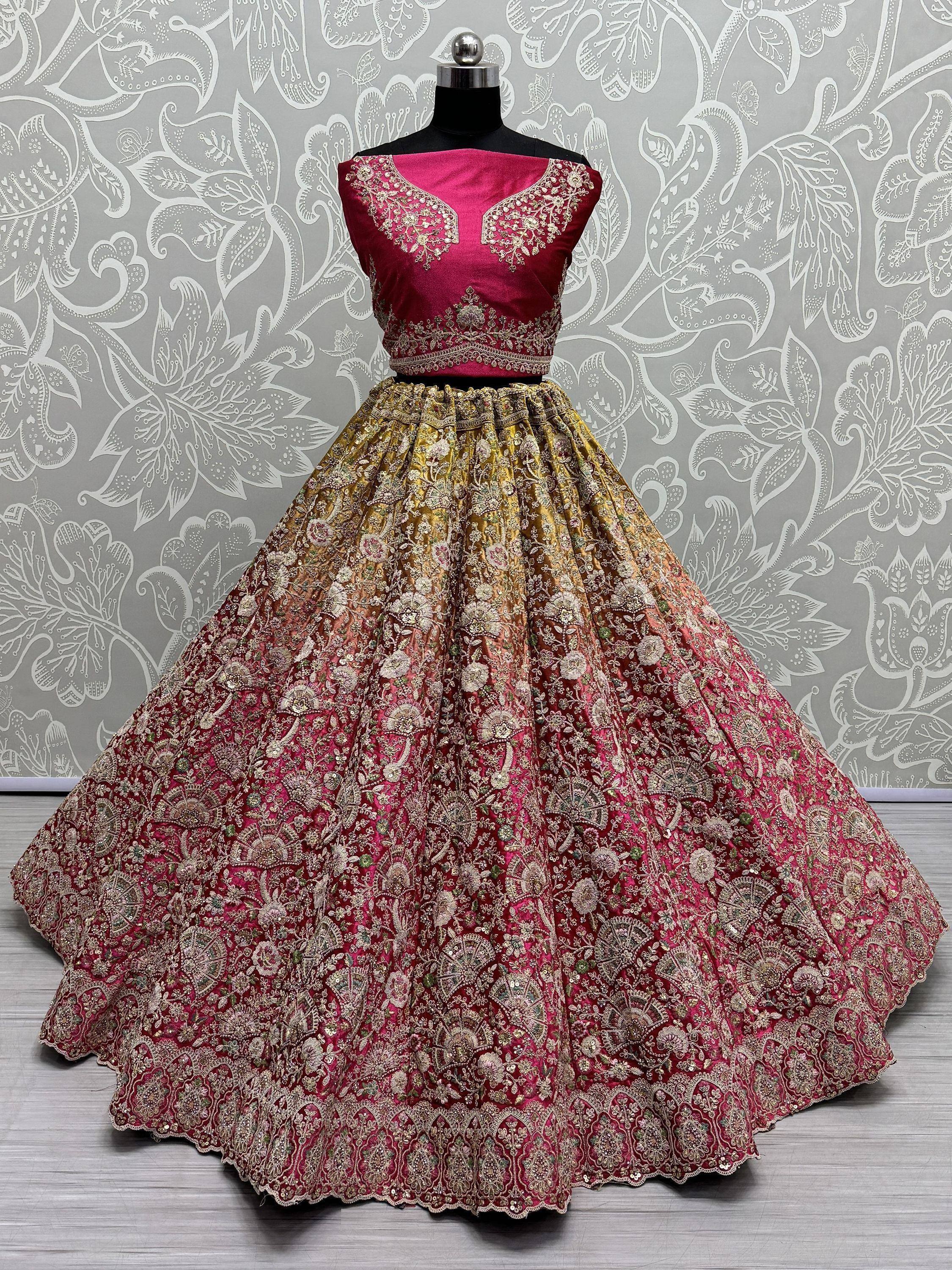 Pink and gold embroidered lehenga choli with floral motifs, displayed on mannequin against patterned backdrop