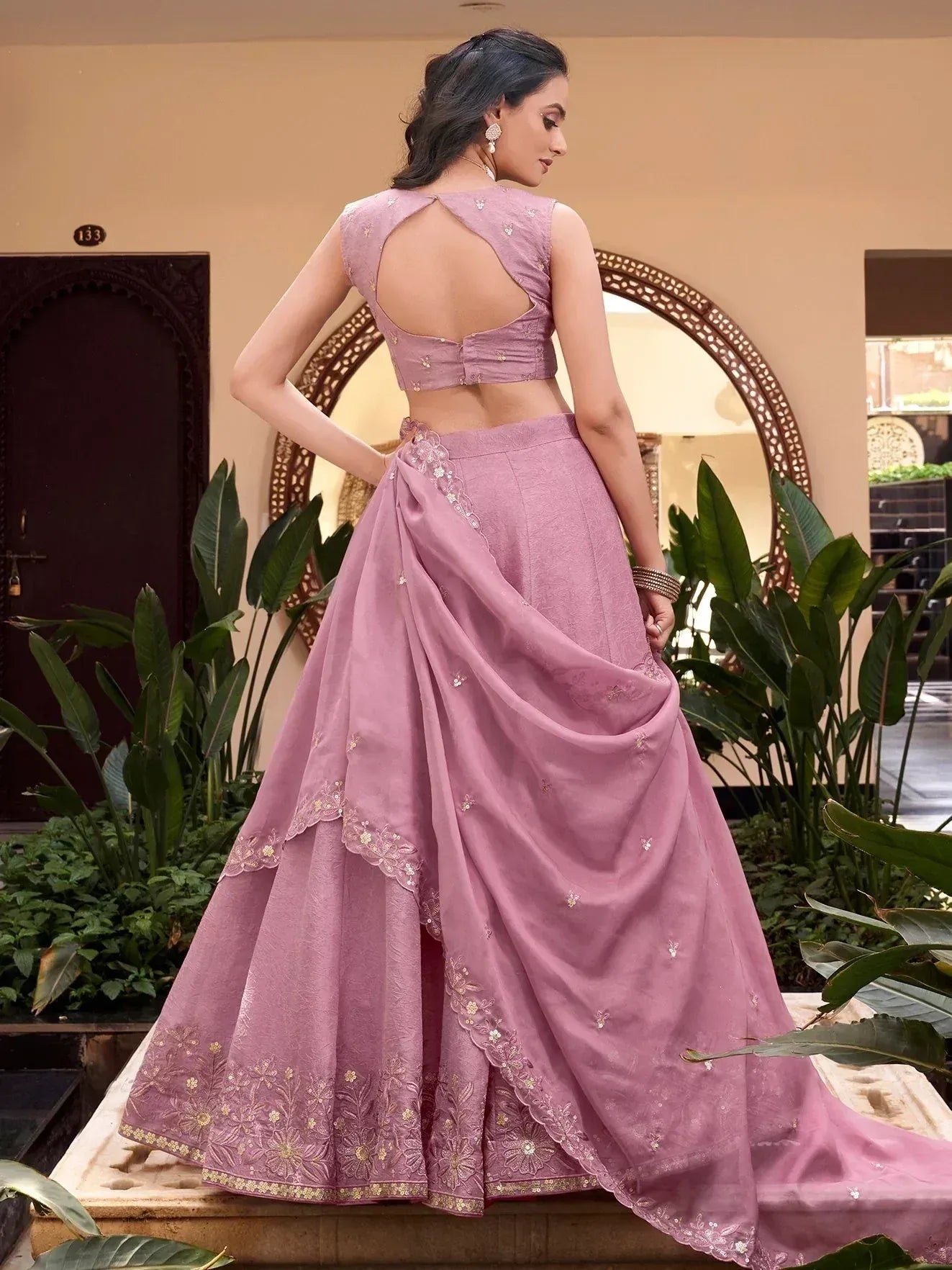 Pink designer lehenga choli with floral embroidery and open back, perfect for Indian ethnic wear occasions