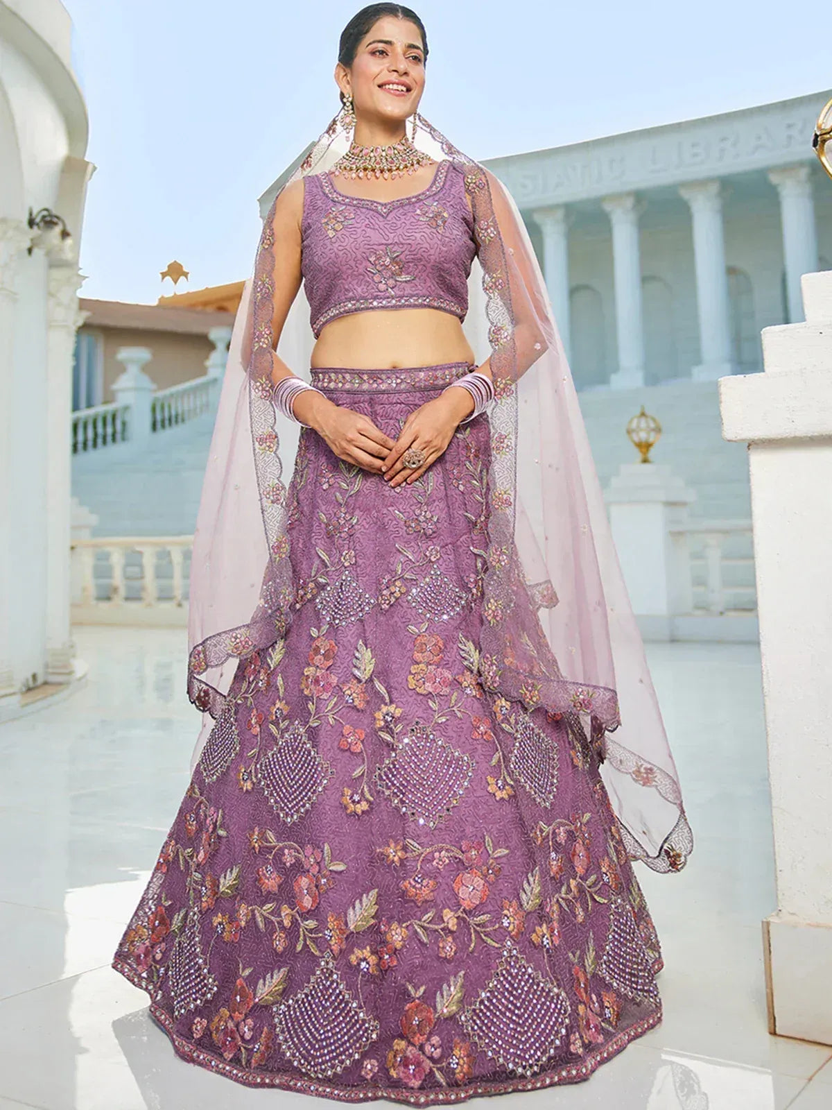 Purple floral embroidered lehenga choli with sheer dupatta, perfect for Indian weddings and festive occasions.