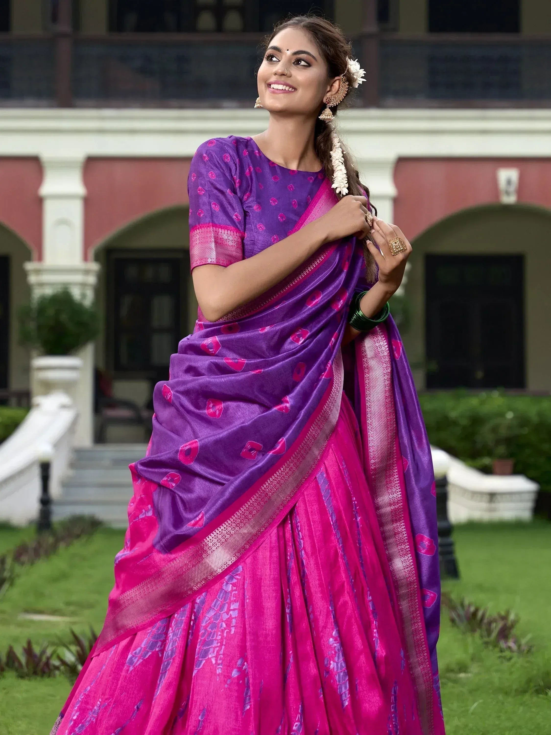 Woman in purple and pink printed saree with floral border, traditional Indian ethnic wear