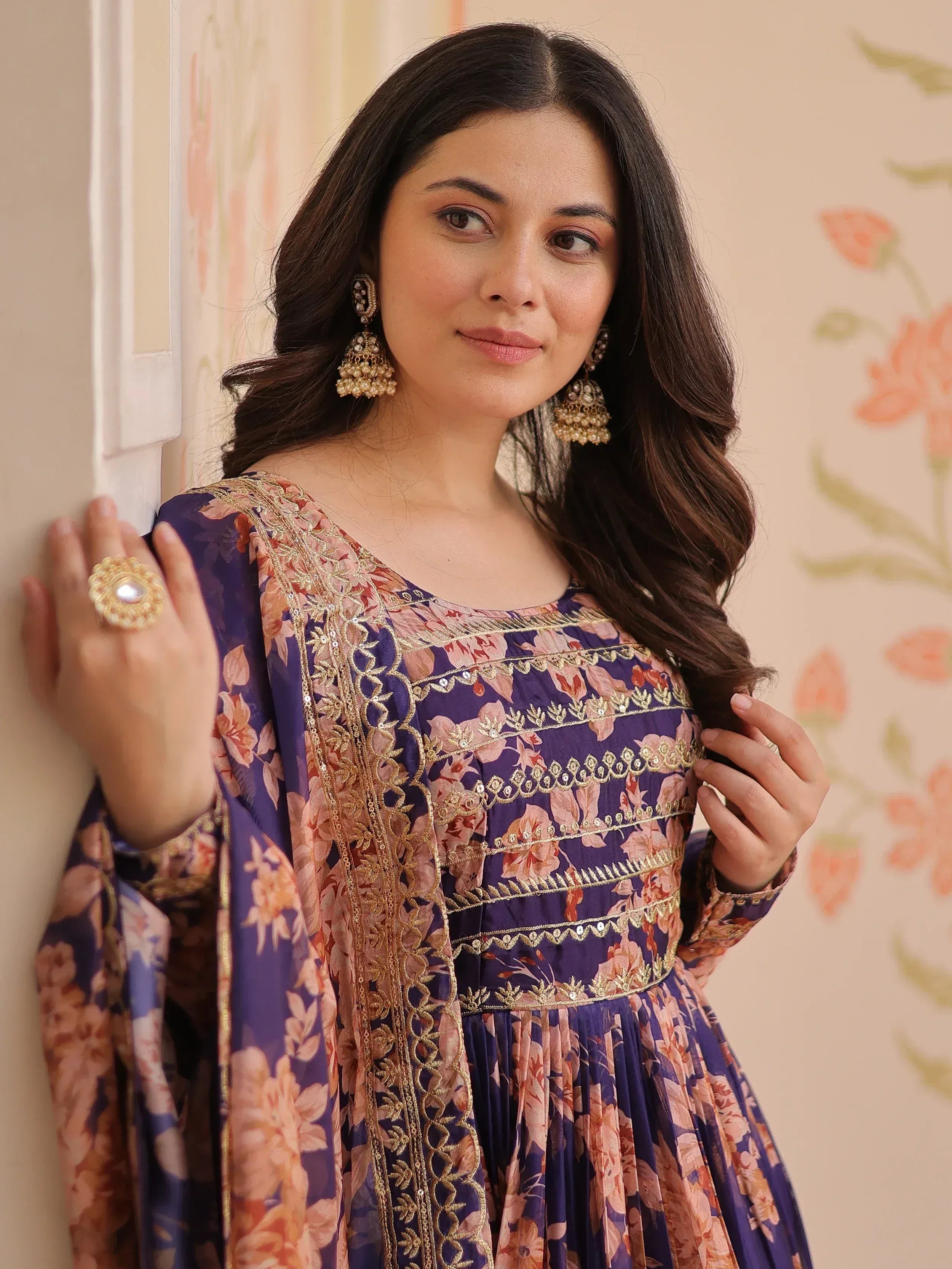 Woman in purple floral ethnic gown with gold embroidery and jhumka earrings