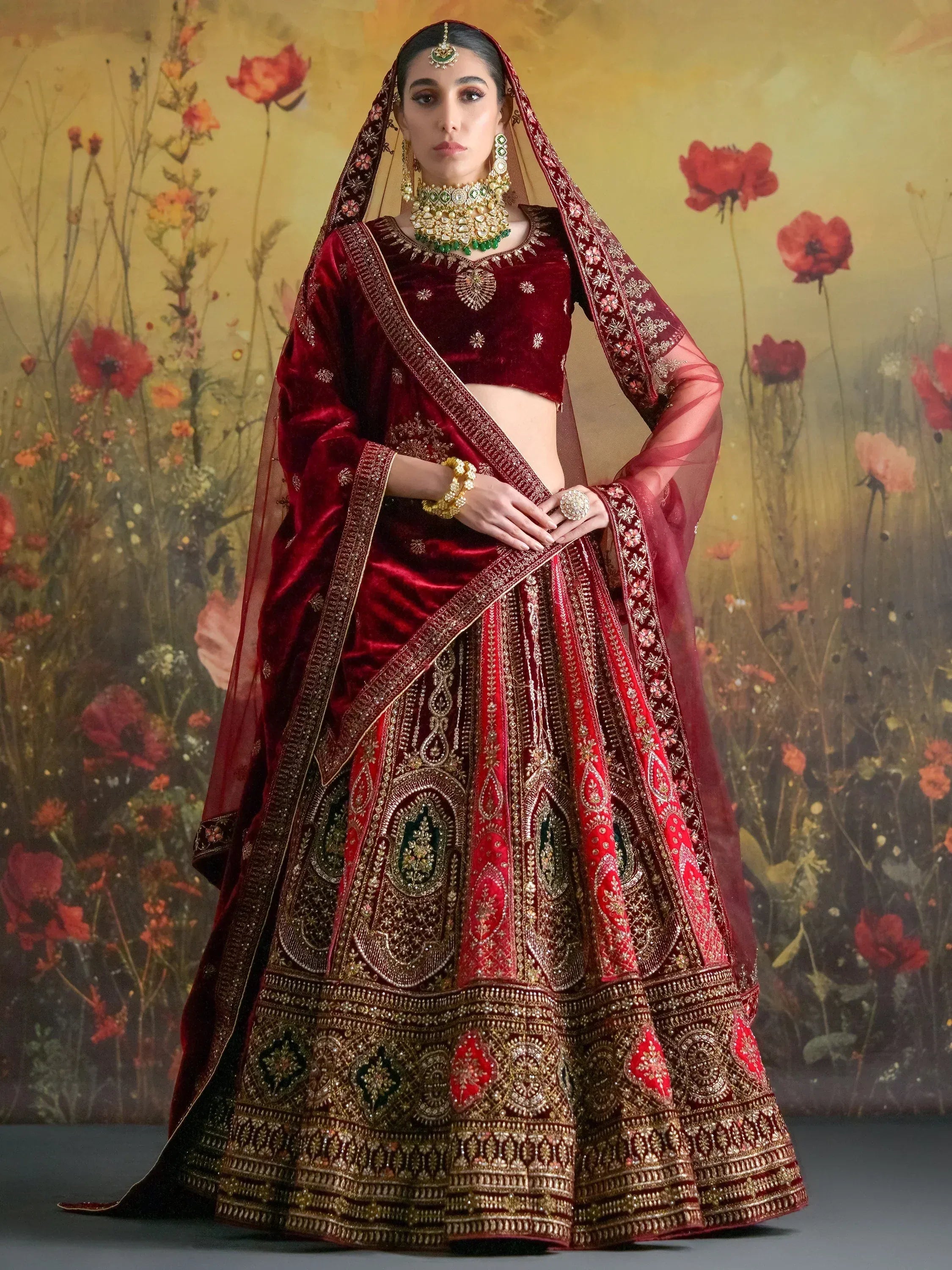 Maroon velvet lehenga choli with heavy gold embroidery, perfect for Indian weddings and festive occasions.