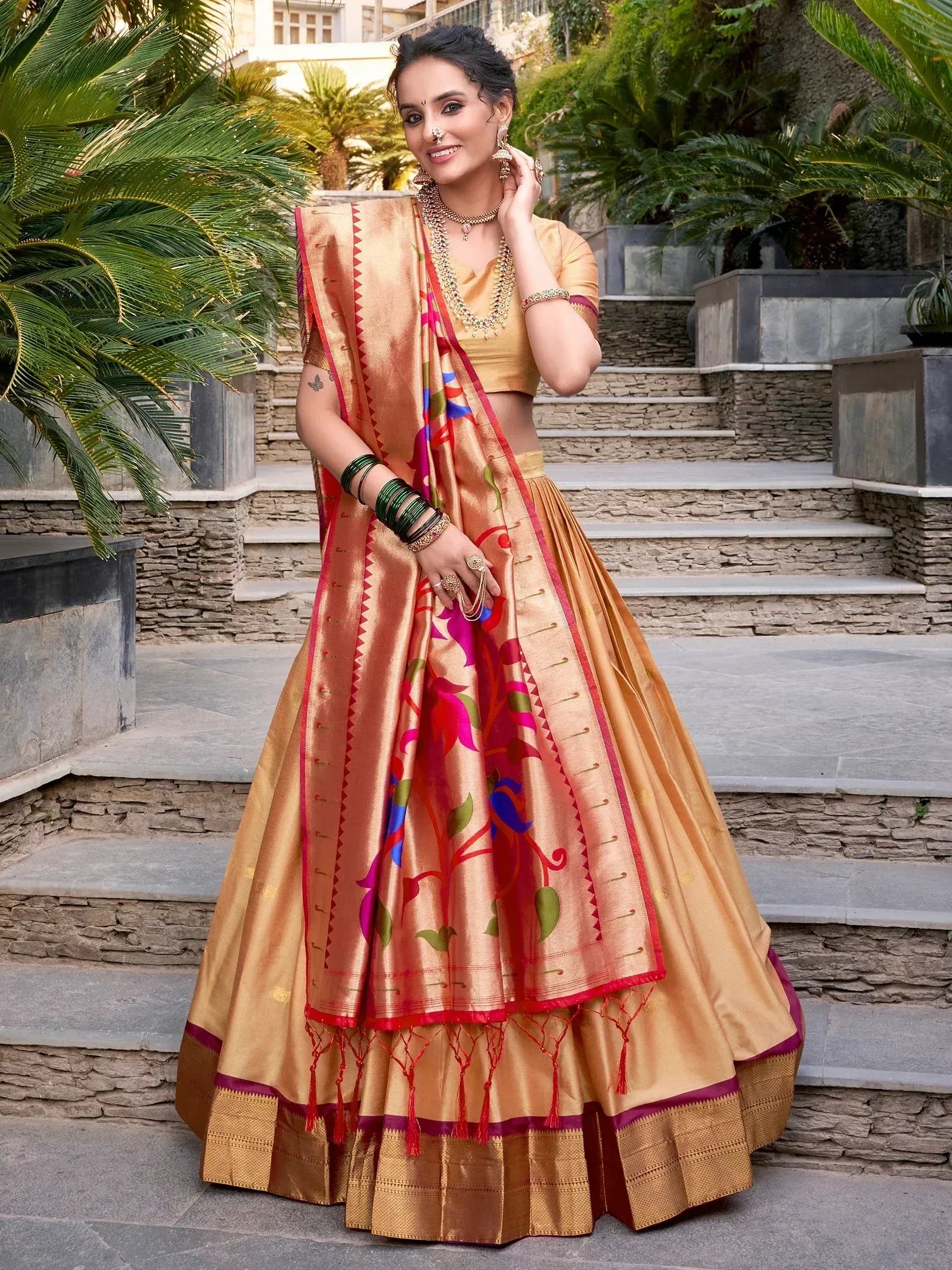 Woman in golden lehenga choli with floral dupatta, traditional Indian ethnic wear for weddings and festivals