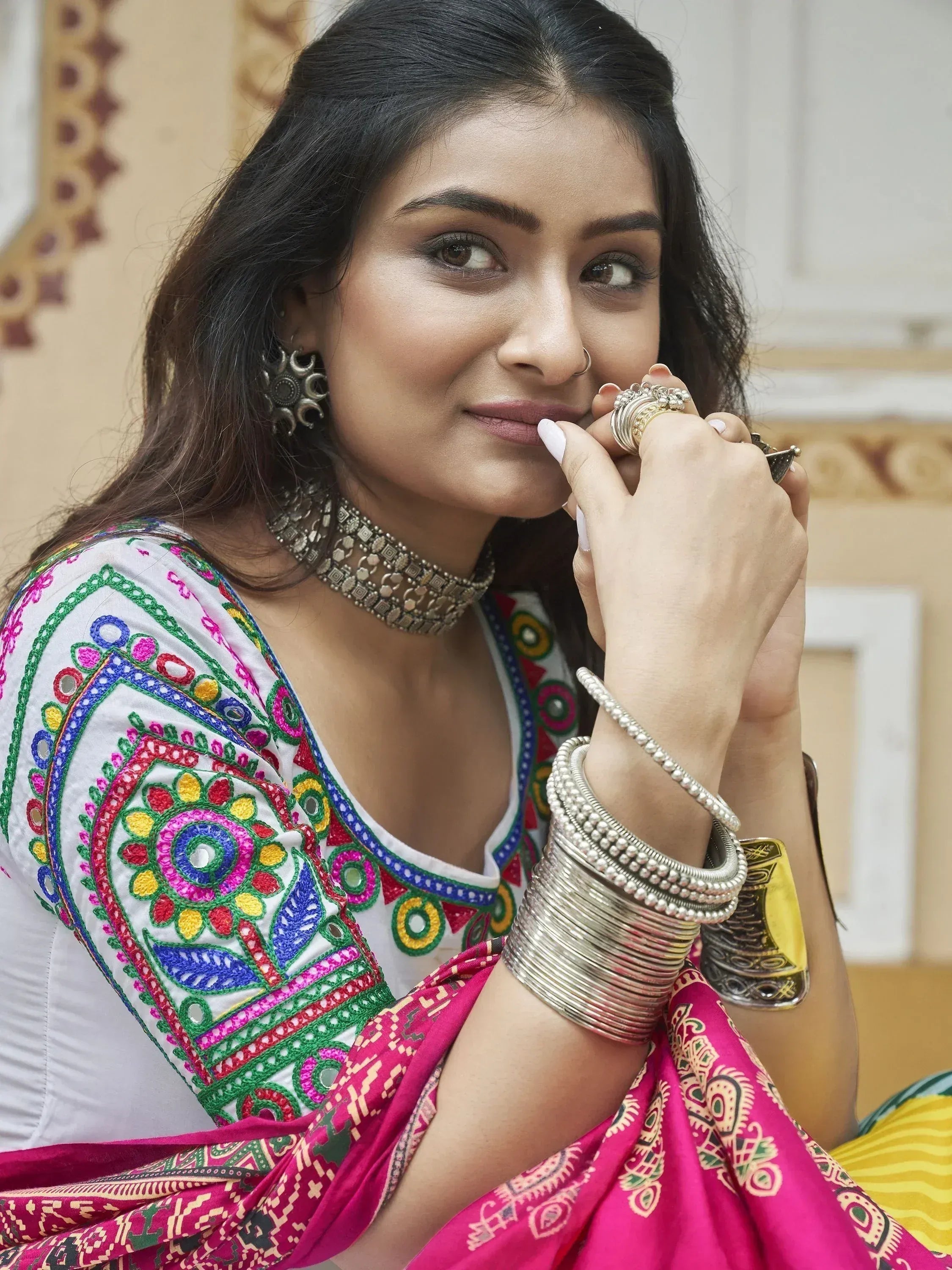 Woman in colorful embroidered Indian ethnic wear with traditional jewelry and bangles