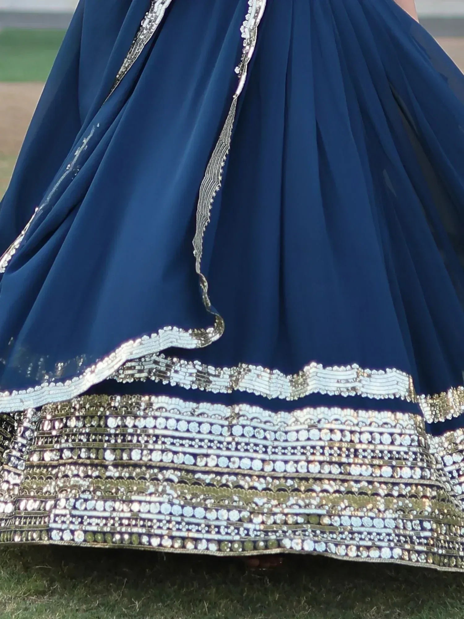 Navy blue lehenga with intricate silver and gold mirror work, perfect for Indian ethnic wear occasions.